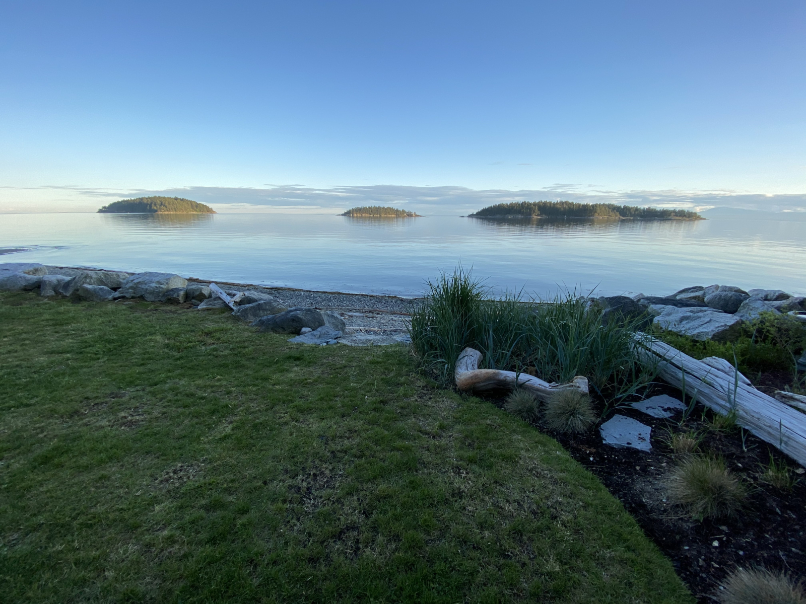 Rocks arranged as steps from the lawn to the beach. The Trail Islands a short paddle away. There are ...