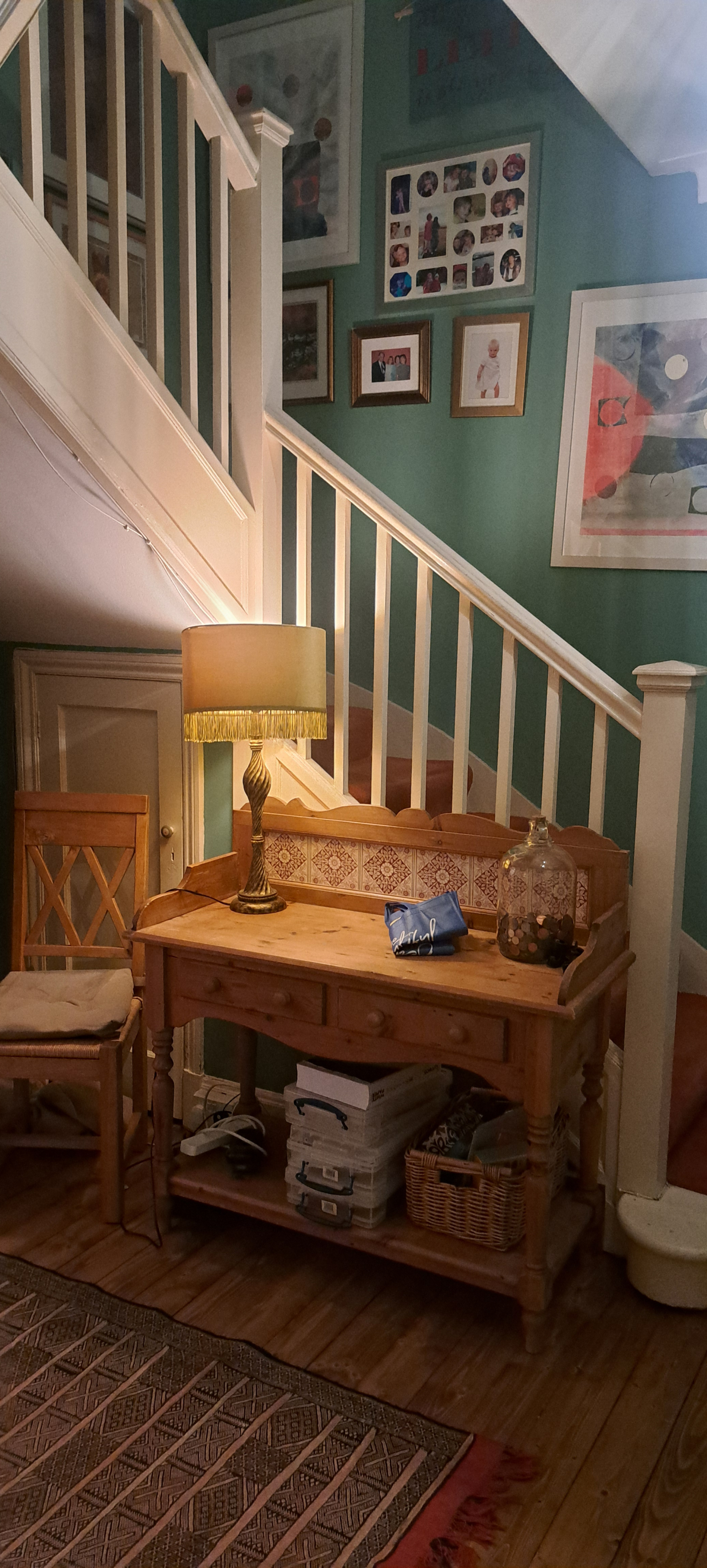 De gang en trap die je begroeten als je binnenkomt via de groene voordeur.