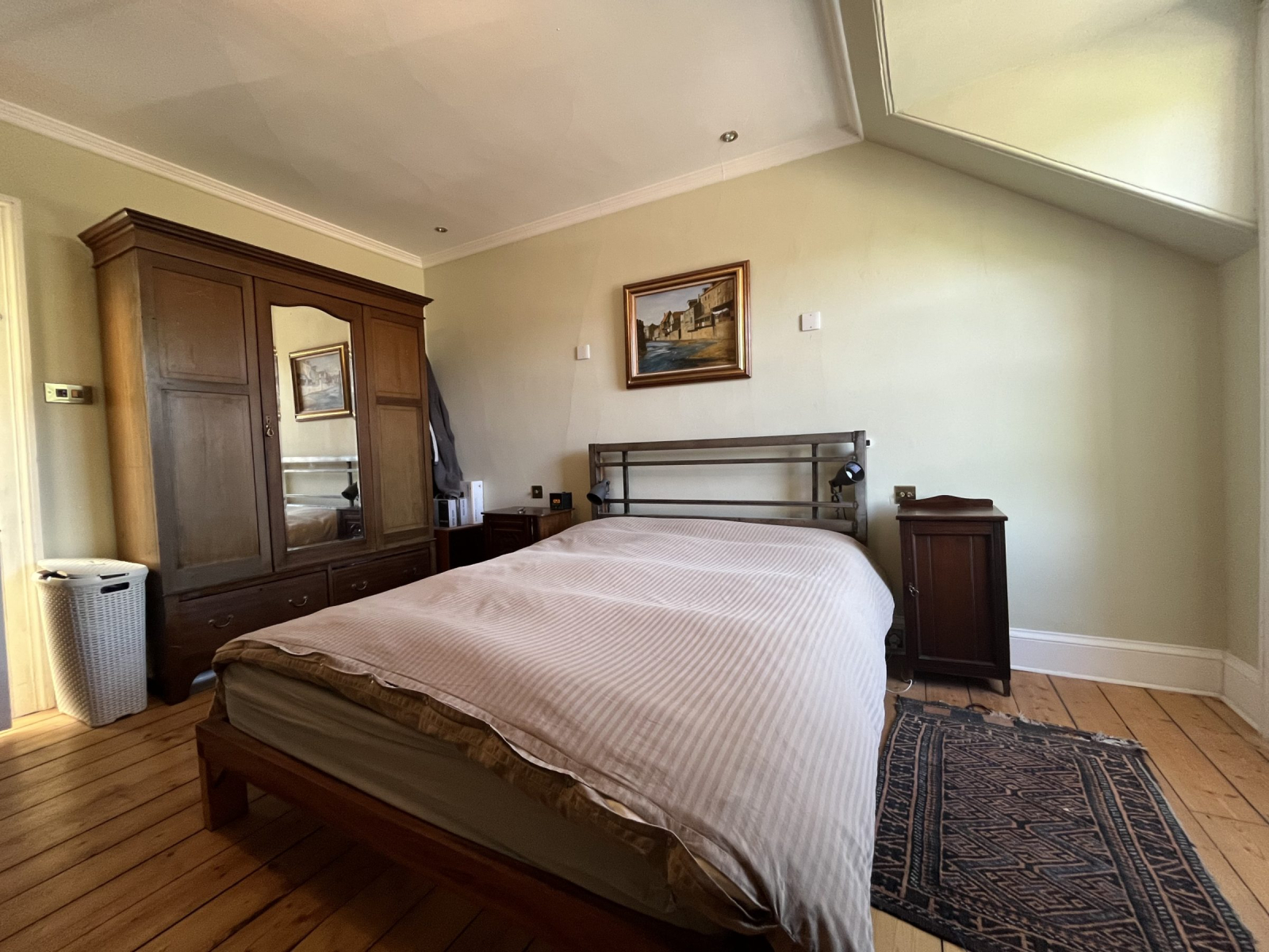 Quarto principal espaçoso no último andar da casa da cidade. Cama king size, com duas mesinhas de ca ...