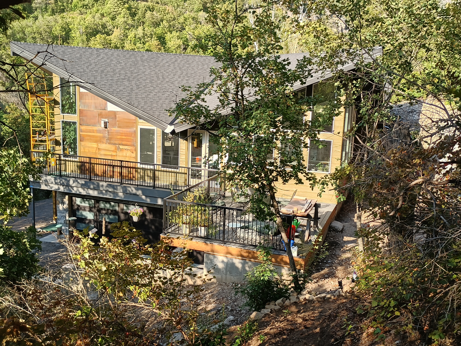 View of west side of house from the forest, also showing the back deck.