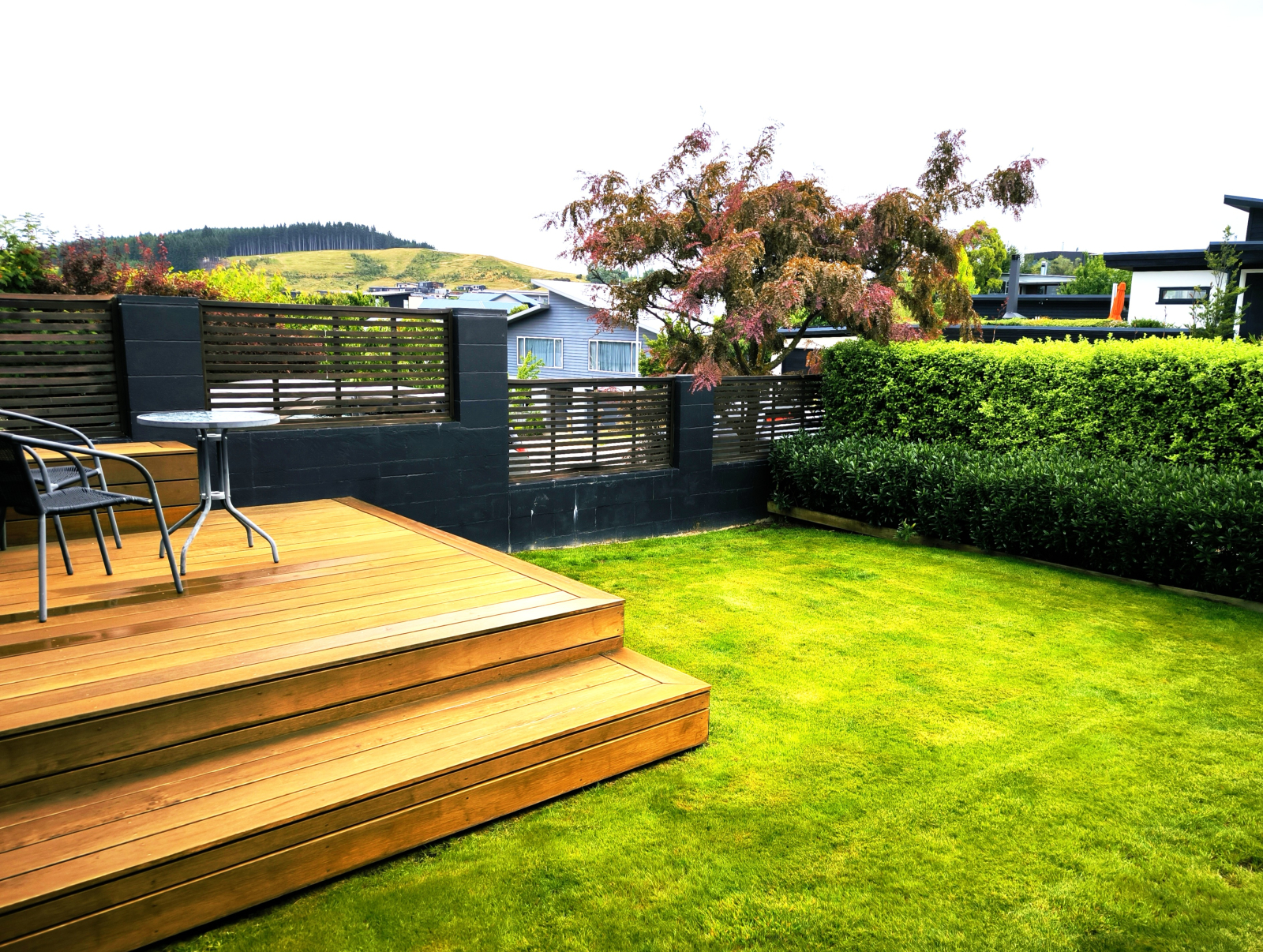 Privater Garten mit Terrasse, Rasen und Gartenmöbeln.