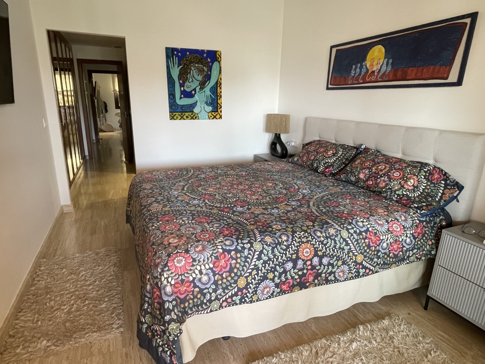 Hoofdslaapkamer met uitzicht op een gang met kasten richting de logeerbadkamer en slaapkamer