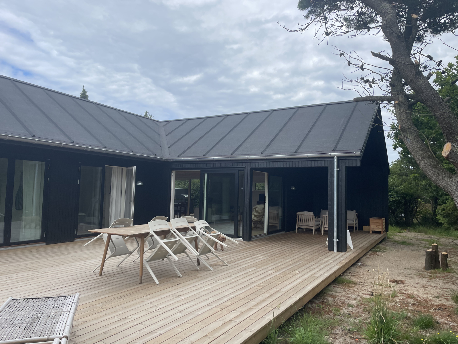 La casa desde el lado del jardín, con la sala de estar que tiene el acceso a la terraza cubierta y l ...