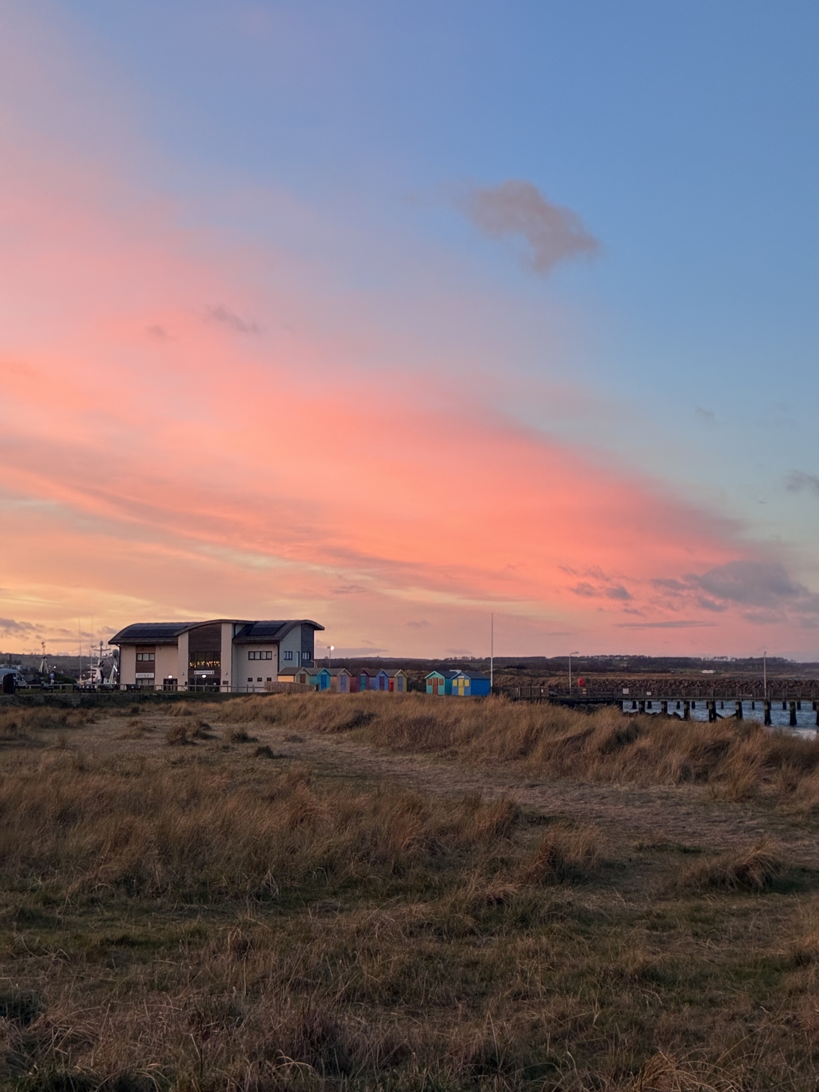 Puesta de sol sobre la Pequeña Costa y las cabañas de la playa.