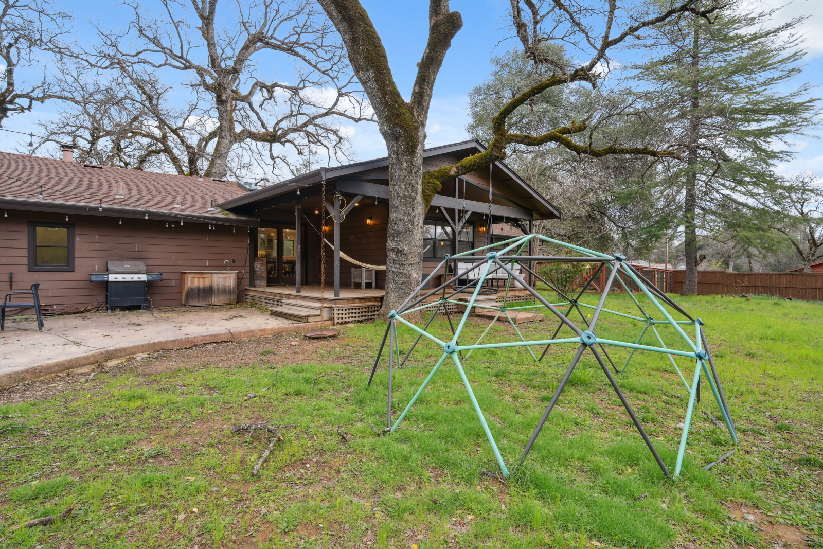 Ampio cortile recintato con ponte, patio, amaca, altalena e cupola per arrampicarsi.