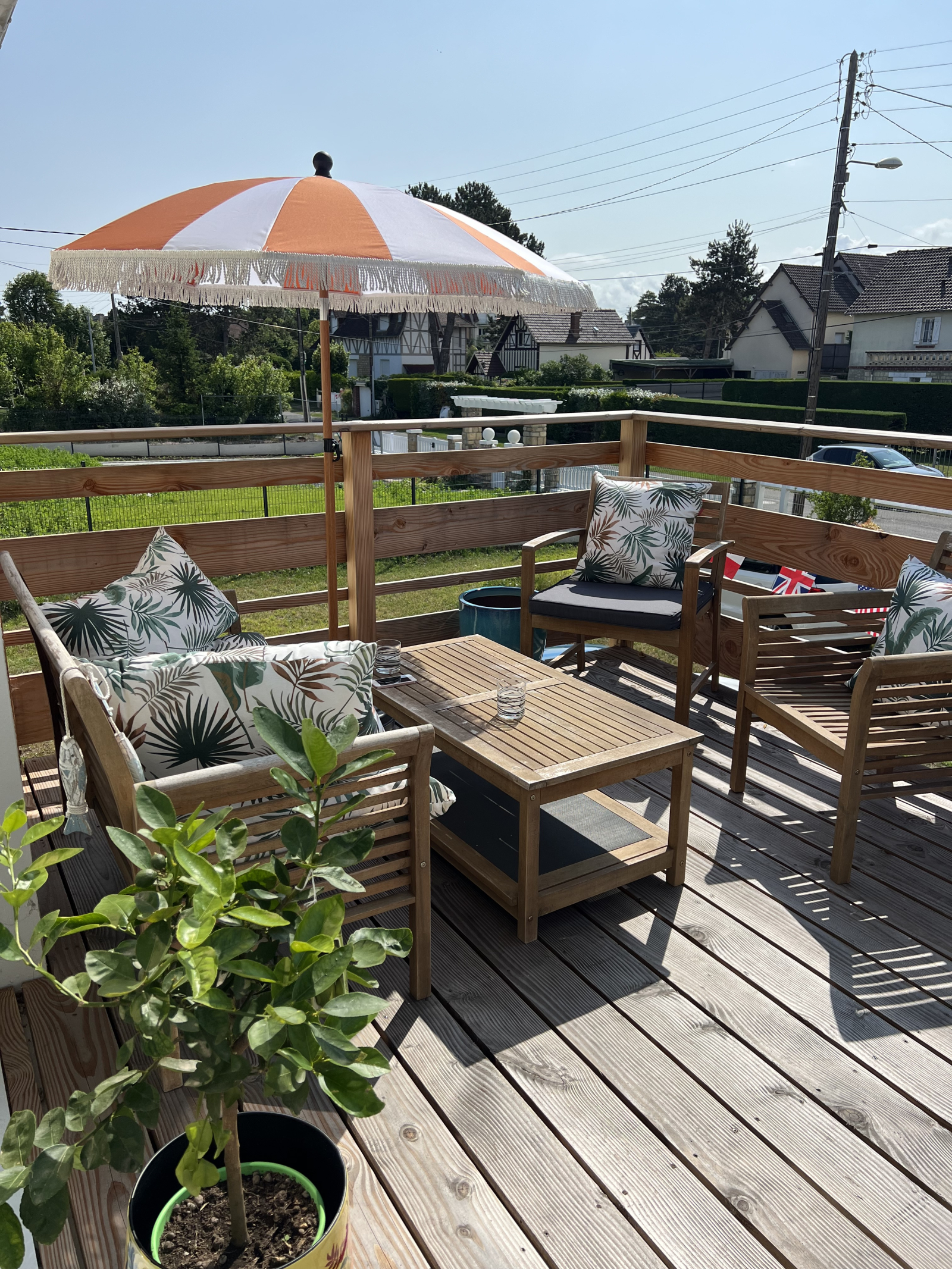 Terrazza in legno sospesa di fronte alla casa a cui si accede attraverso la sala da pranzo e il lato ...