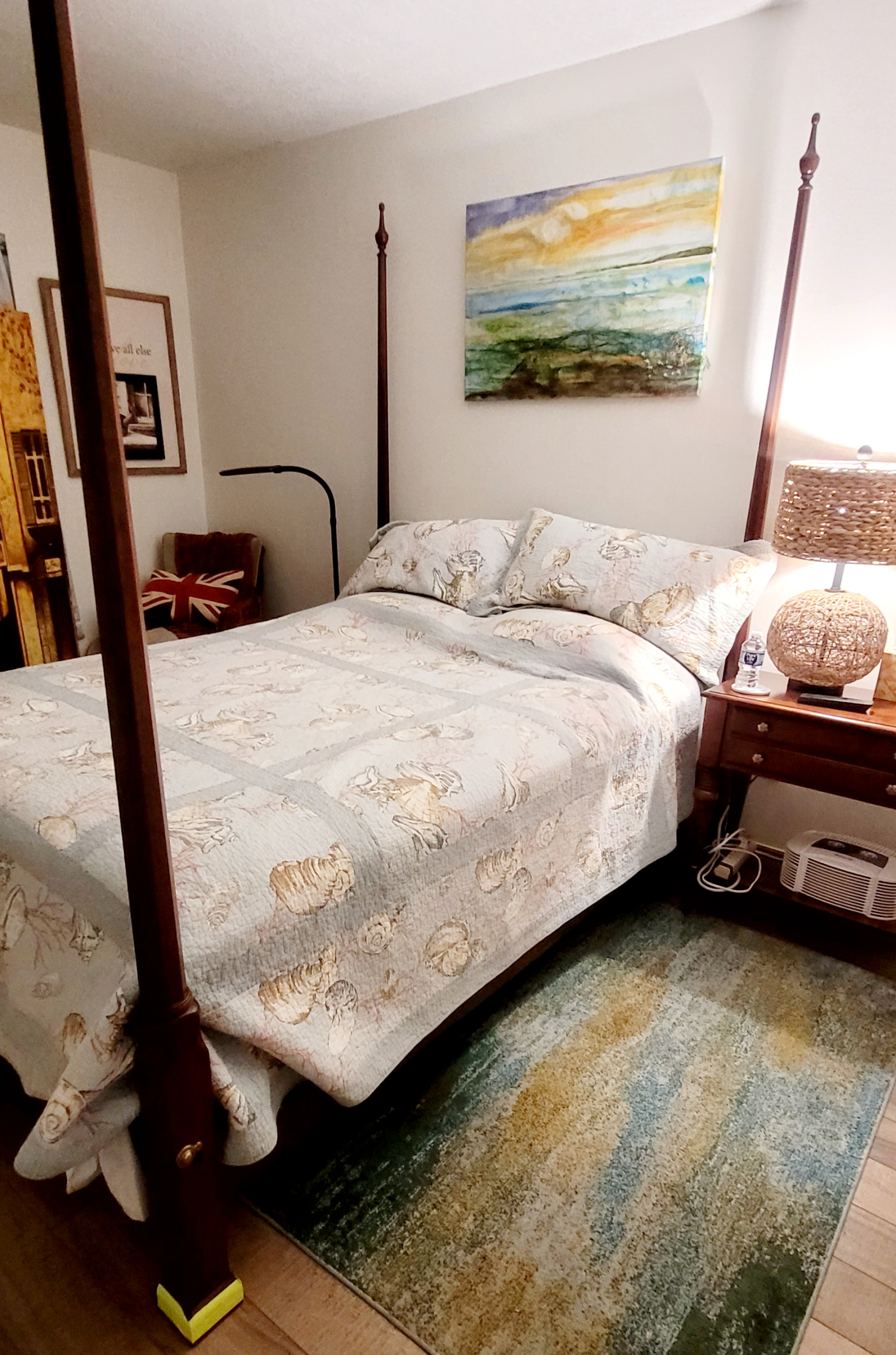 O quarto queen size com mesa e armário e tv de tela plana