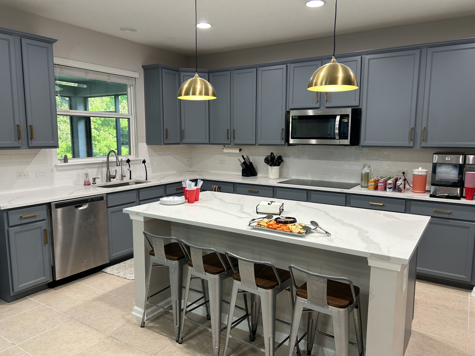 Amplia cocina con horno doble, estufa de inducción, microondas, máquina de hielo y una isla grande.