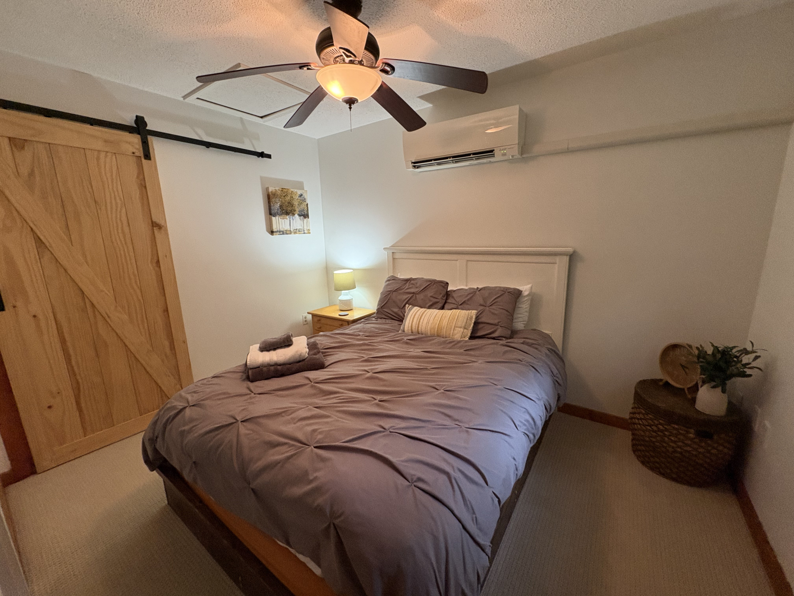 Queen size slaapkamer heeft twee lades in nachtkastje, kast met hangers en bagagerek.