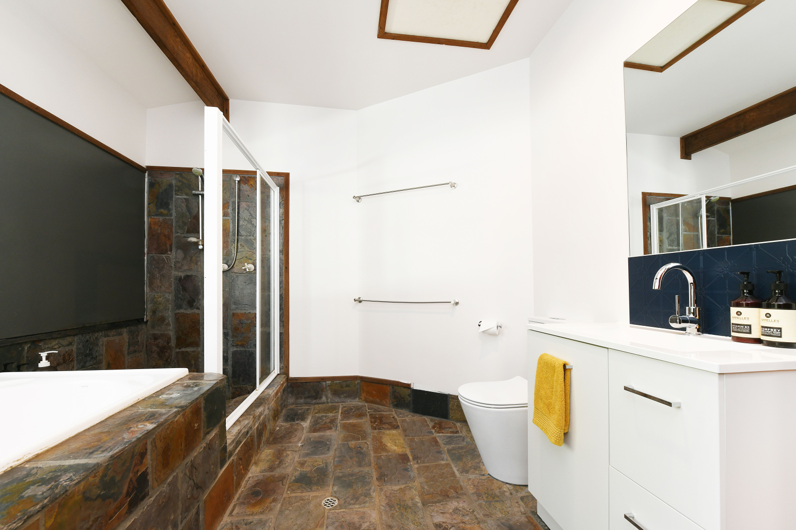 Salle de bain principale avec douche, baignoire, vanité, toilettes qui dessert la chambre 2