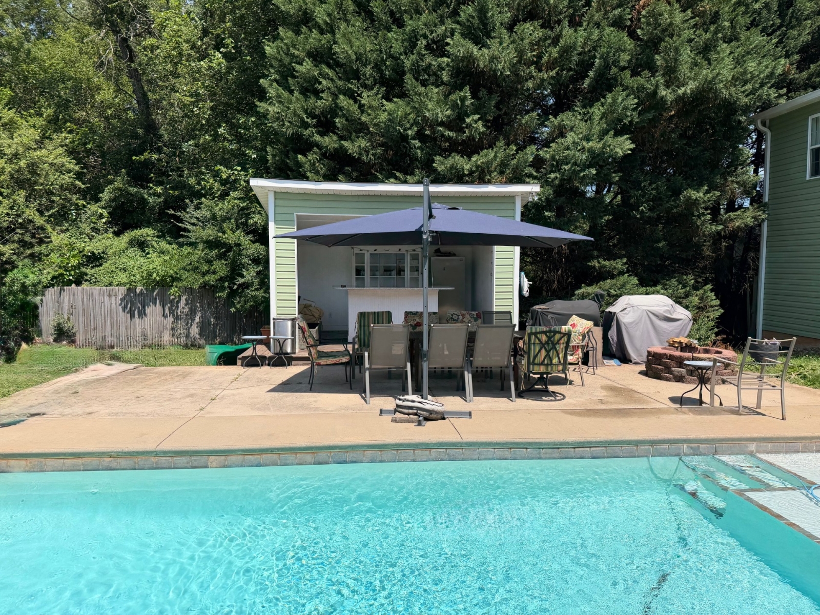 Outdoor Oasis met eetplaatsen voor 8 personen, een grillstation en een vuurplaats.
