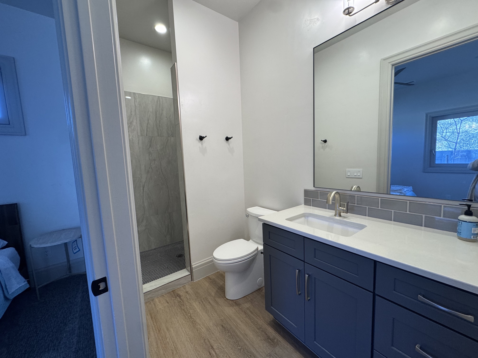 Salle de bain attenante à droite avec vue sur la douche.