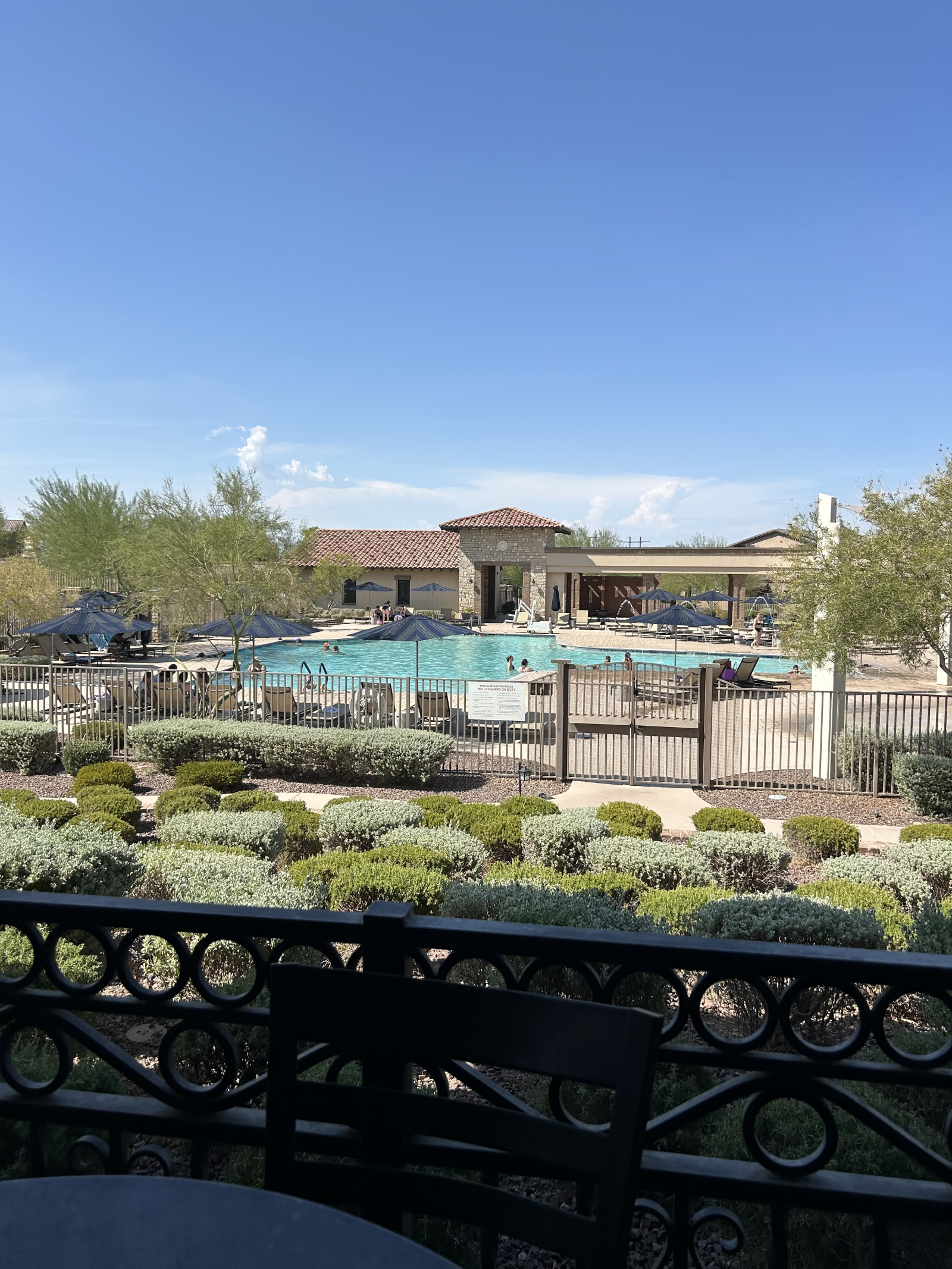 Piscina comunitaria estilo centro turístico con tumbonas, áreas sombreadas y mucho espacio para rela ...