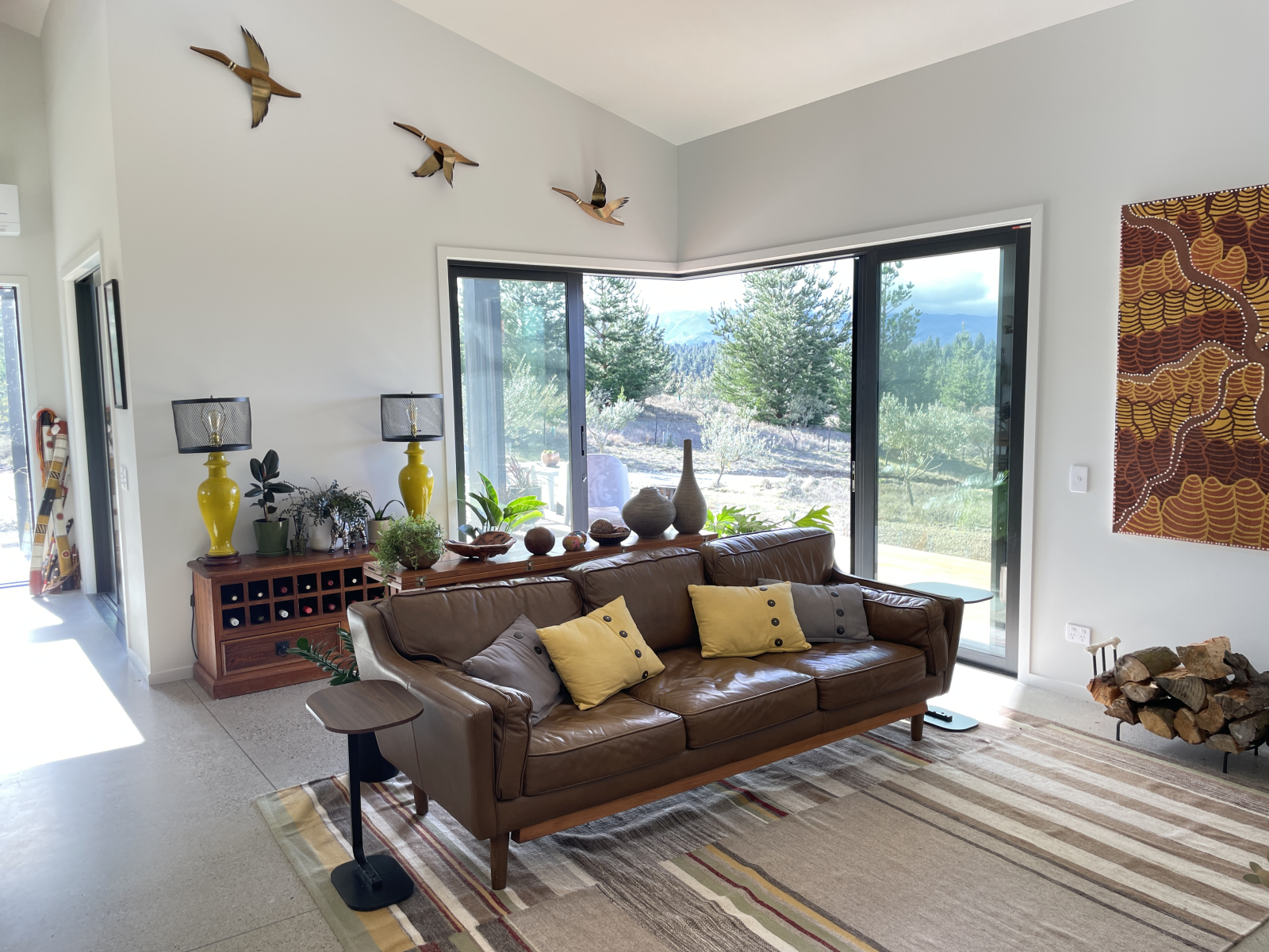 Gemütliche Lounge mit Holzofen, Gidja-Kunst und viel Grün. Großzügige Türen öffnen sich vollständig ...