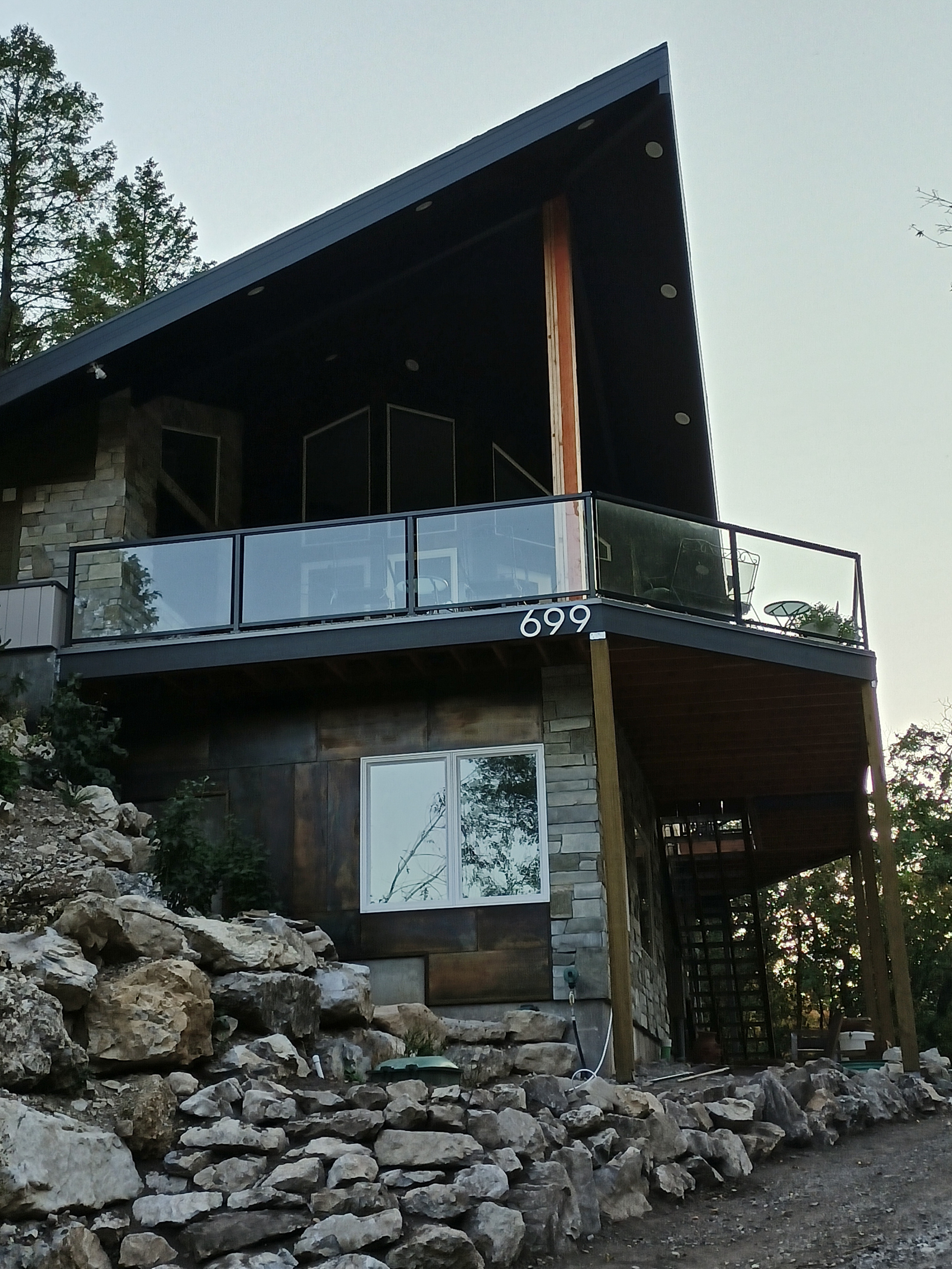 View from driveway of entry corner showing covered front deck with office window below.