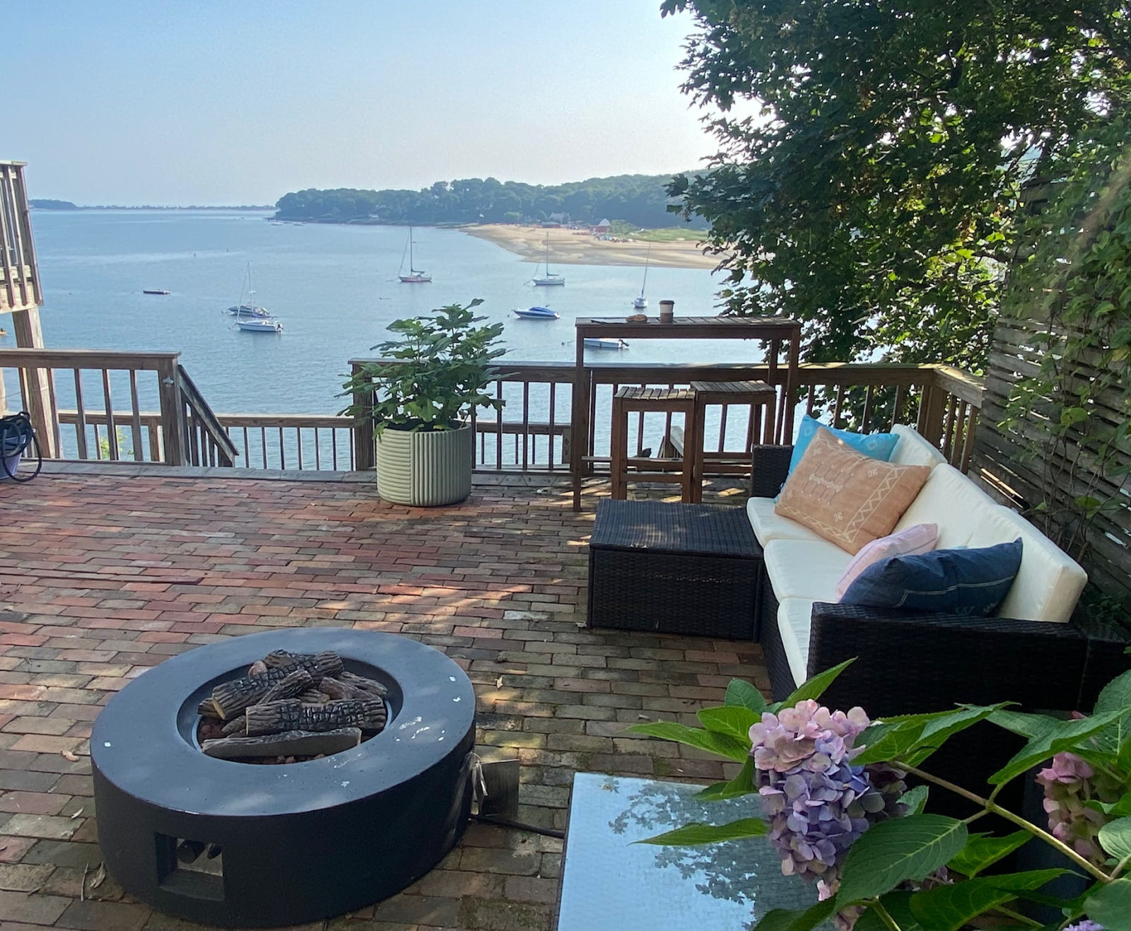 Belle terrasse avec mobilier de salon et foyer au gaz invite à des après-midi de farniente à l’ombre