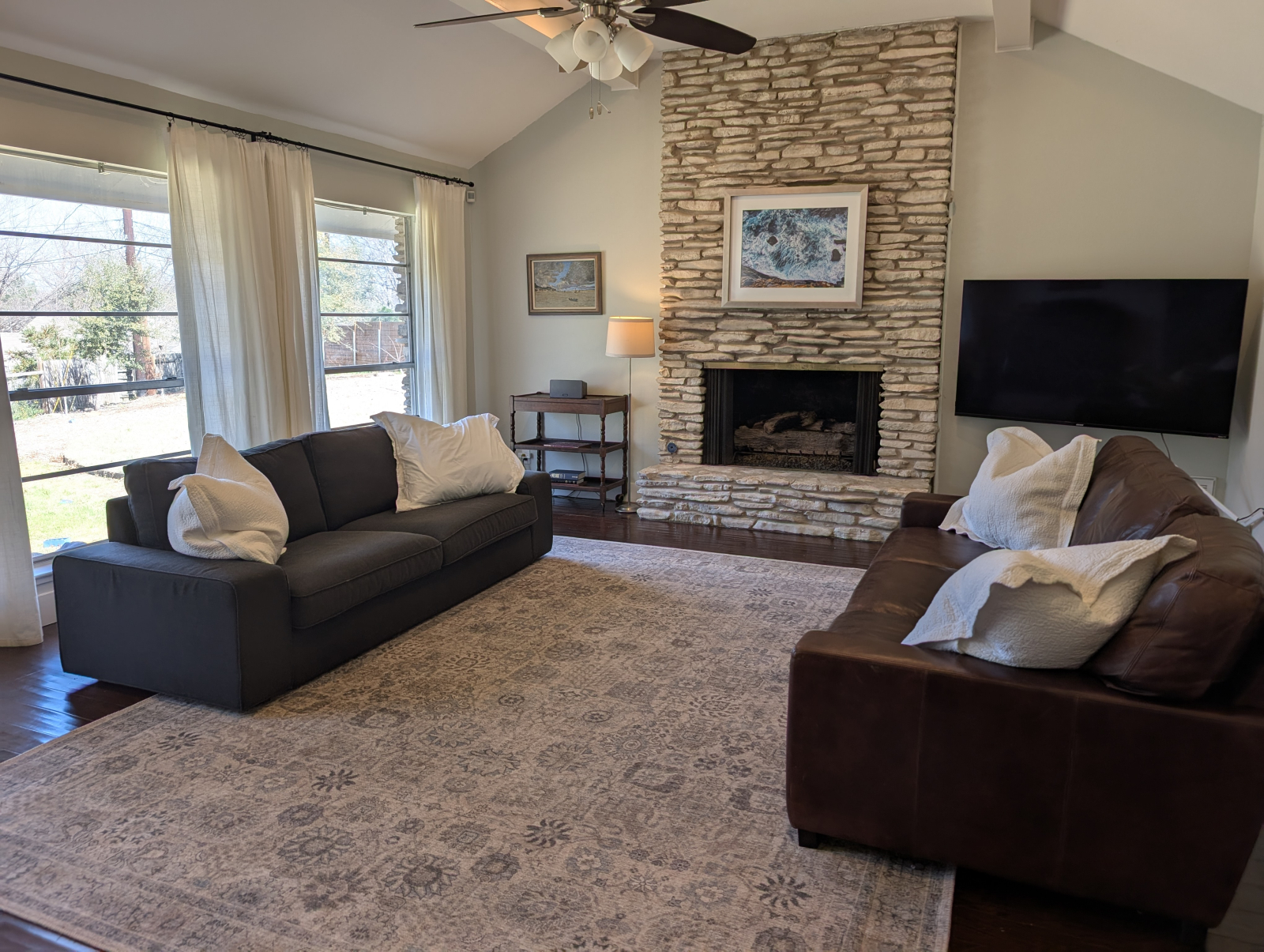 Bright, spacious living room, with smart TV, and couches designed for conversation. Kids toys and bo ...