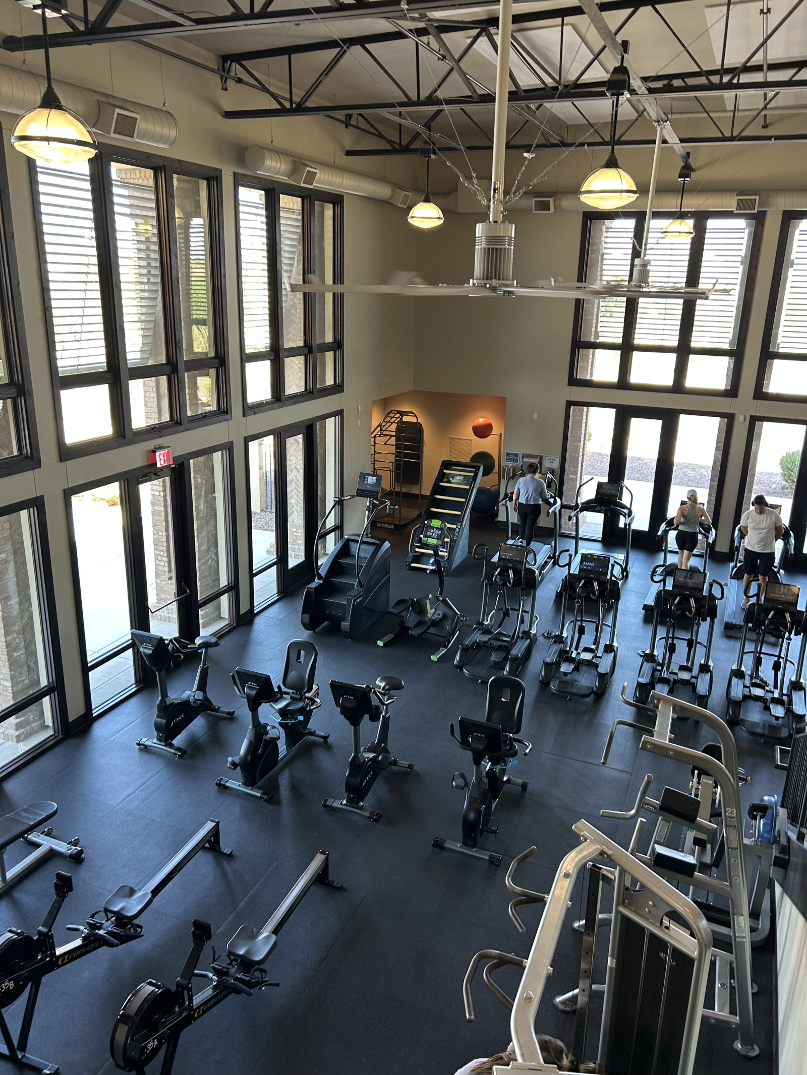 Gimnasio comunitario con una amplia gama de máquinas cardiovasculares, pesas y mucho espacio para ma ...