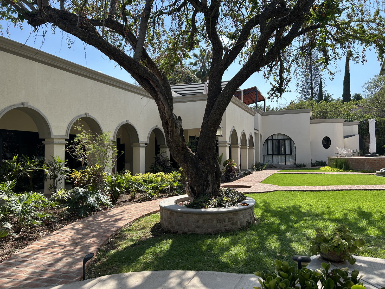 La casa principal y el edificio casita de dos pisos están conectados por una hermosa portola.