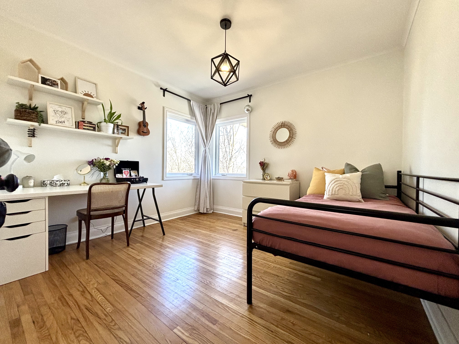 Main floor bedroom with single bed, bright morning light and a view of the yard