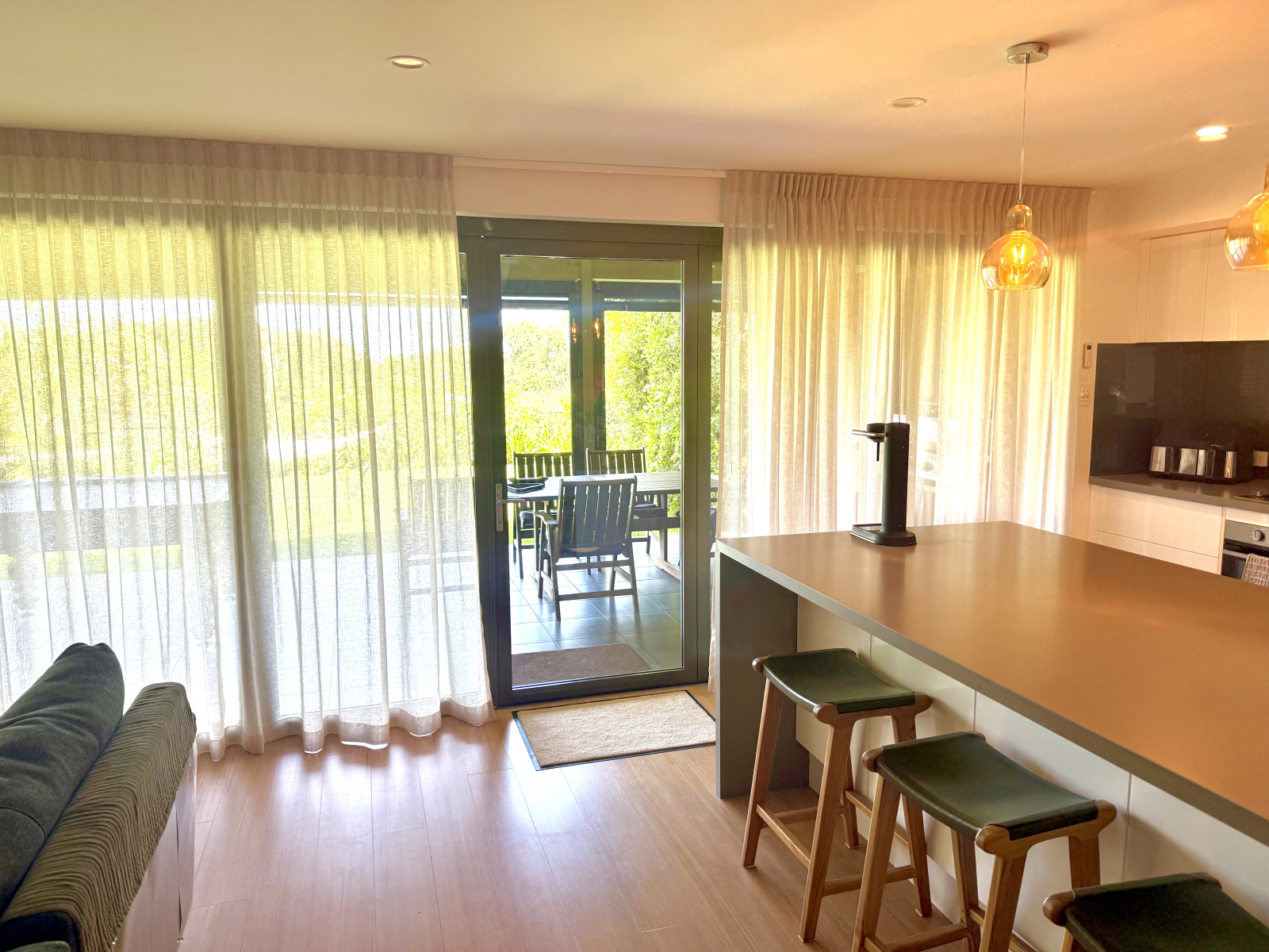 De woonkamer en keuken komen uit op een grote zonnige buitenkeuken met pooltafel en sauna