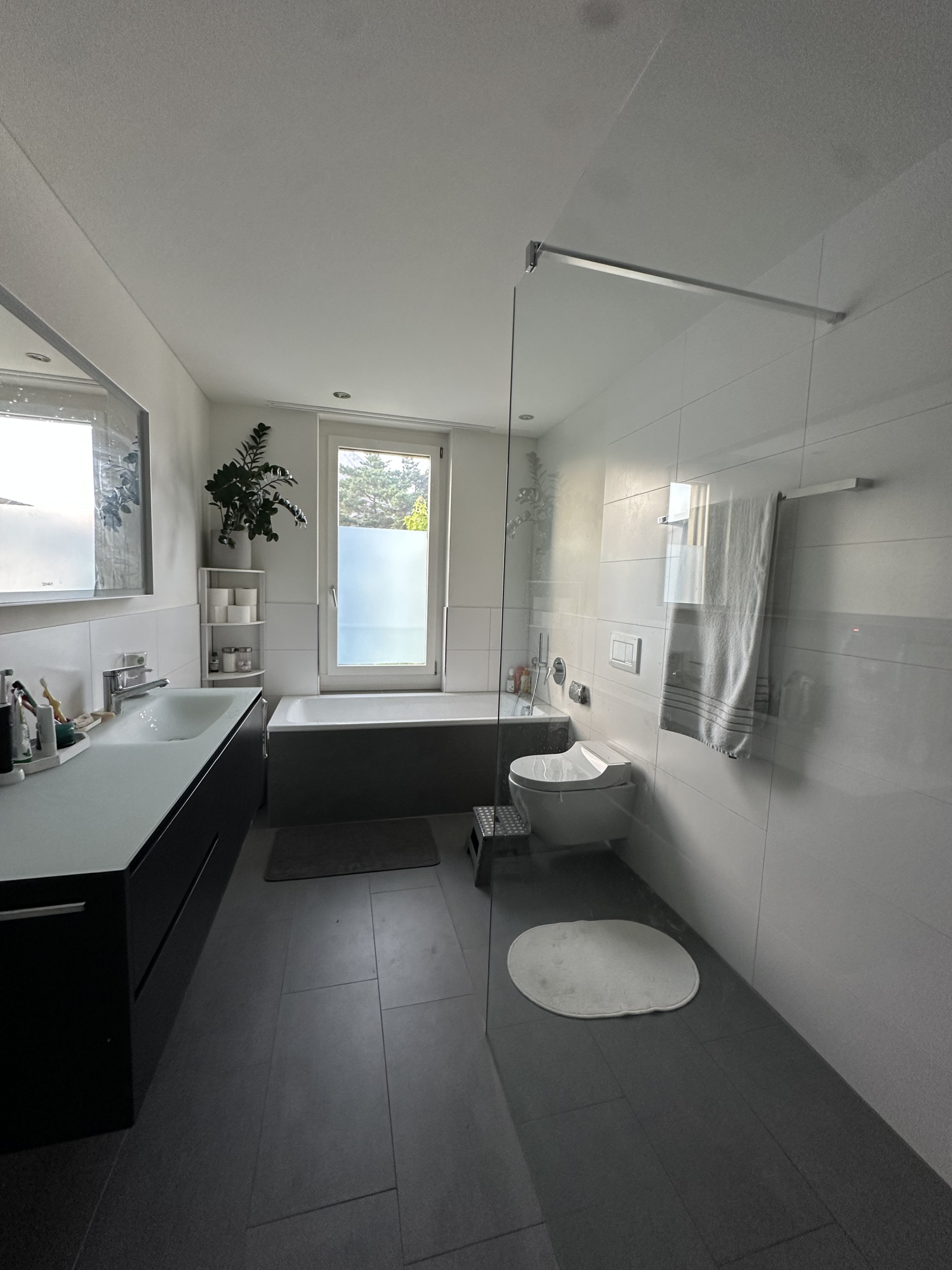 Amplio cuarto de baño con ducha a ras de suelo y bañera separada