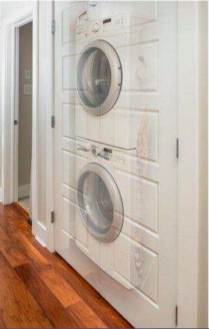 Laveuse (ci-dessous) et sécheuse (ci-dessus) dans le placard utilitaire.