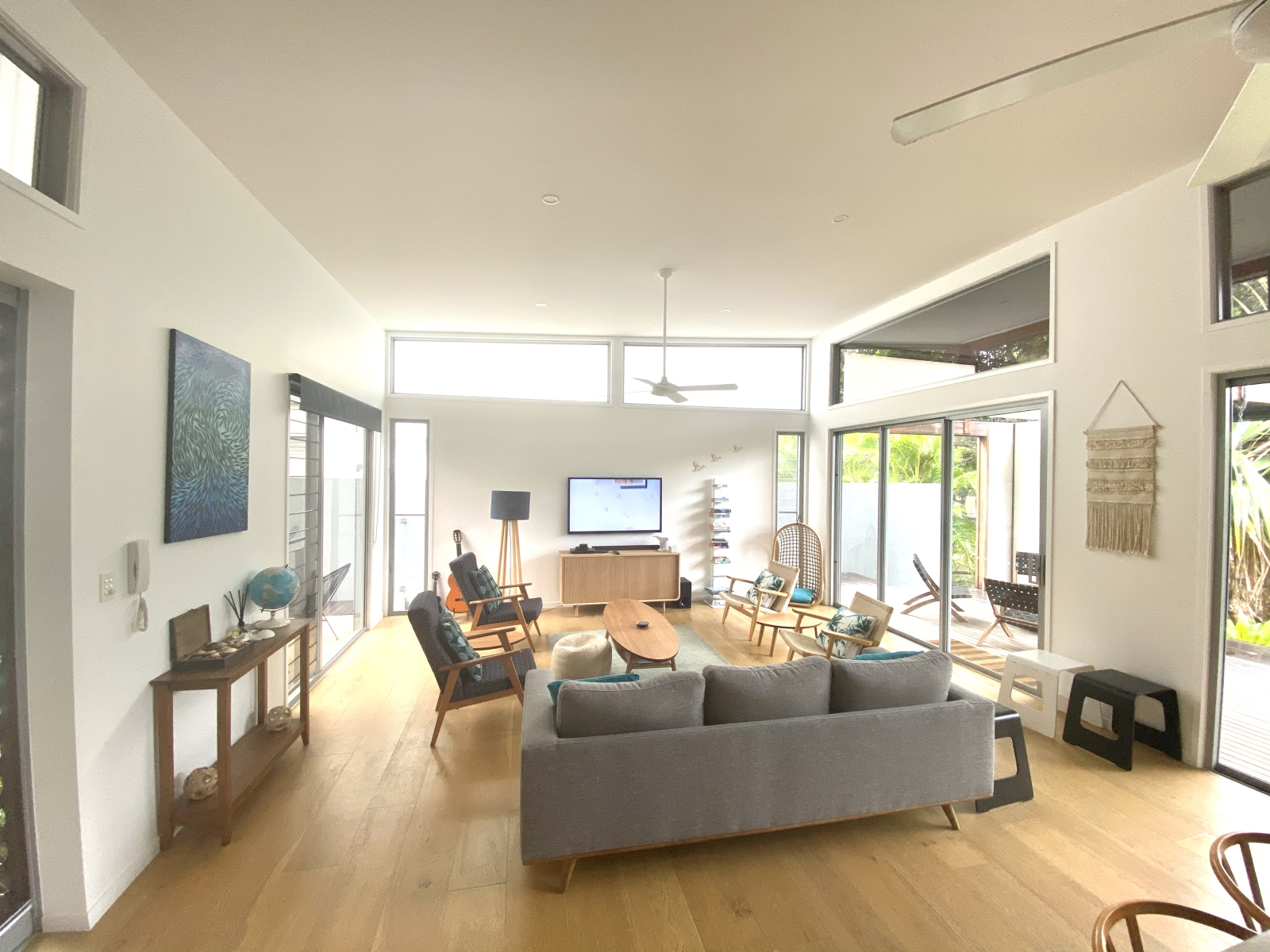 Living room with large deck, 75" TV and multiple streaming services.