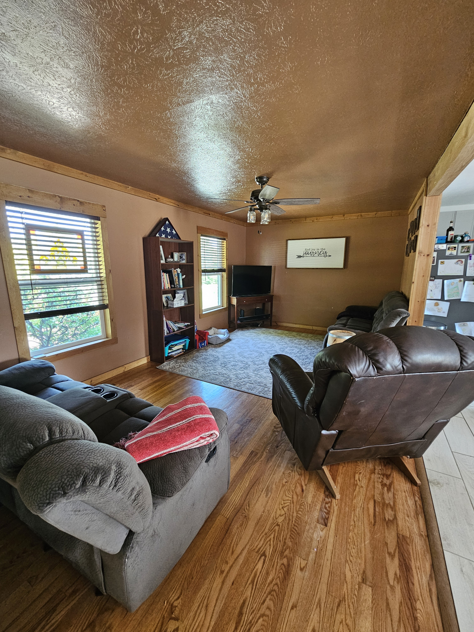 Petit salon avec télévision intelligente, fauteuil inclinable et canapés inclinables.