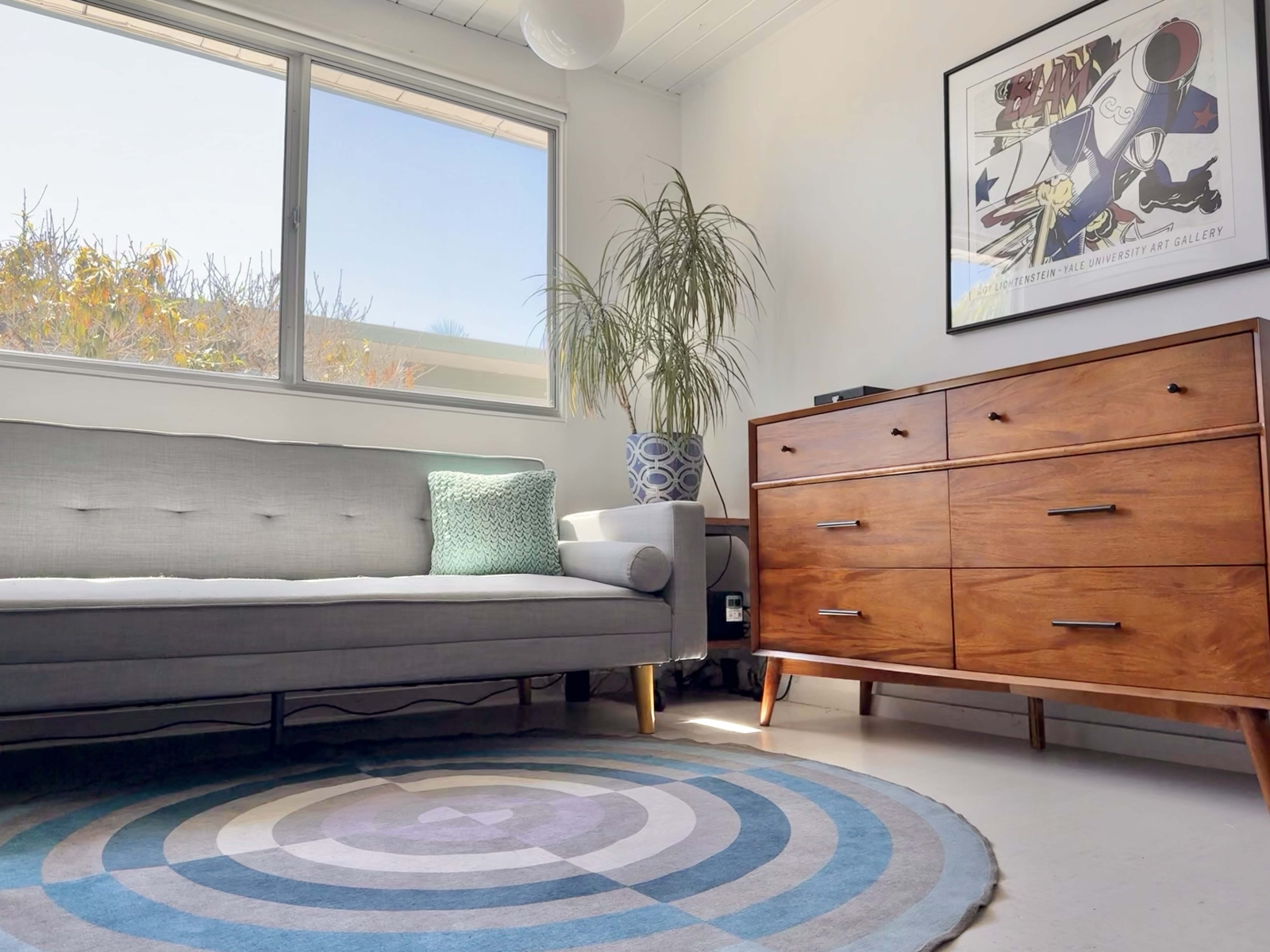 Futon/sofa in this room folds flat into a bed that's somewhere between twin XL and full size.