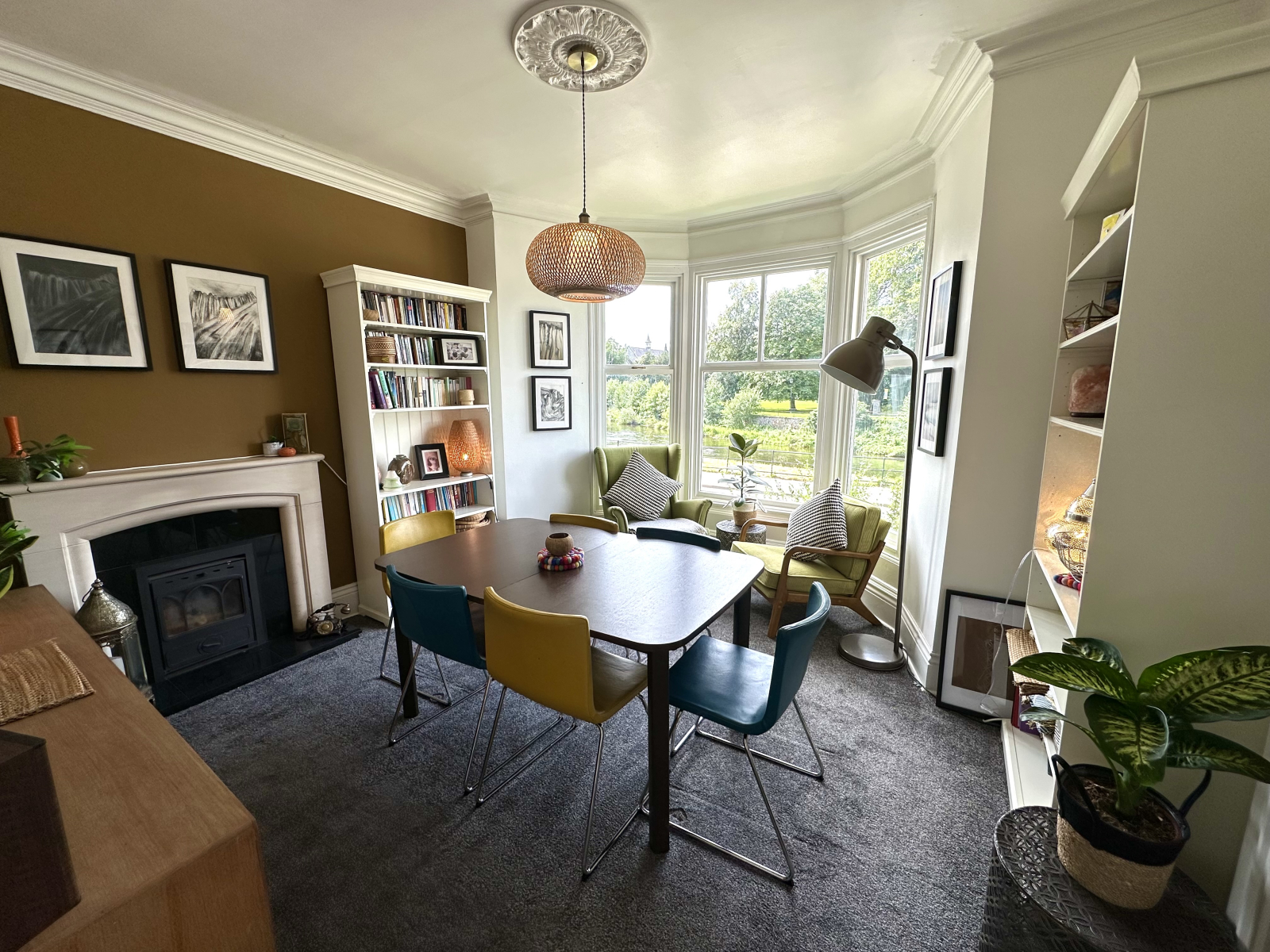 Sala de jantar com lareira e vista para o rio.