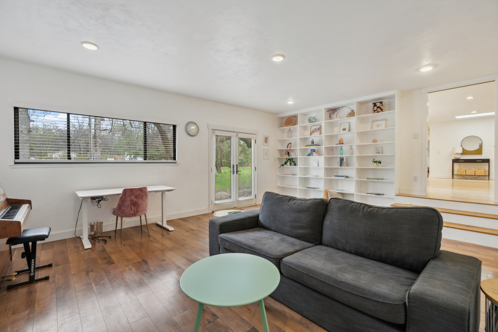 Den con tv, scrivania, pianoforte.