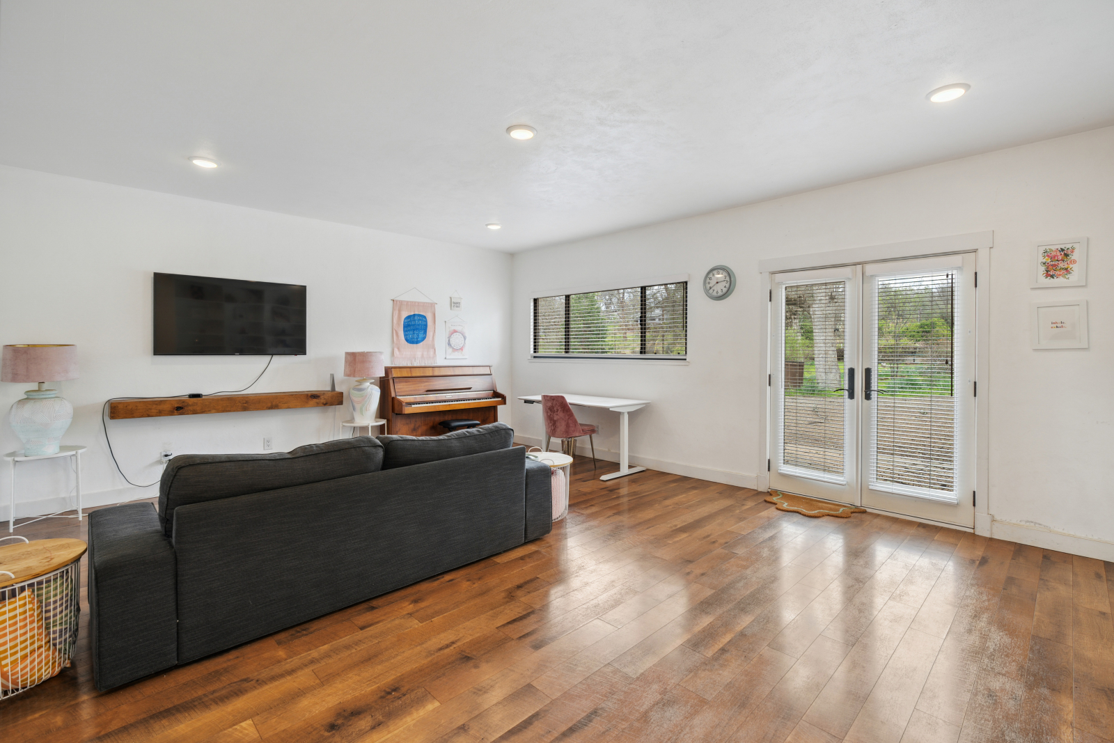 Den con tv, scrivania, pianoforte.