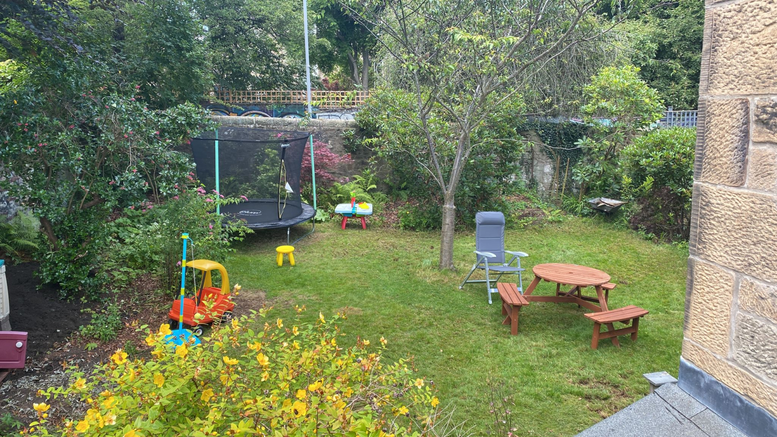 Giardino privato sul retro con cupola di arrampicata, trampolino, tavolo da picnic e giochi per bamb ...