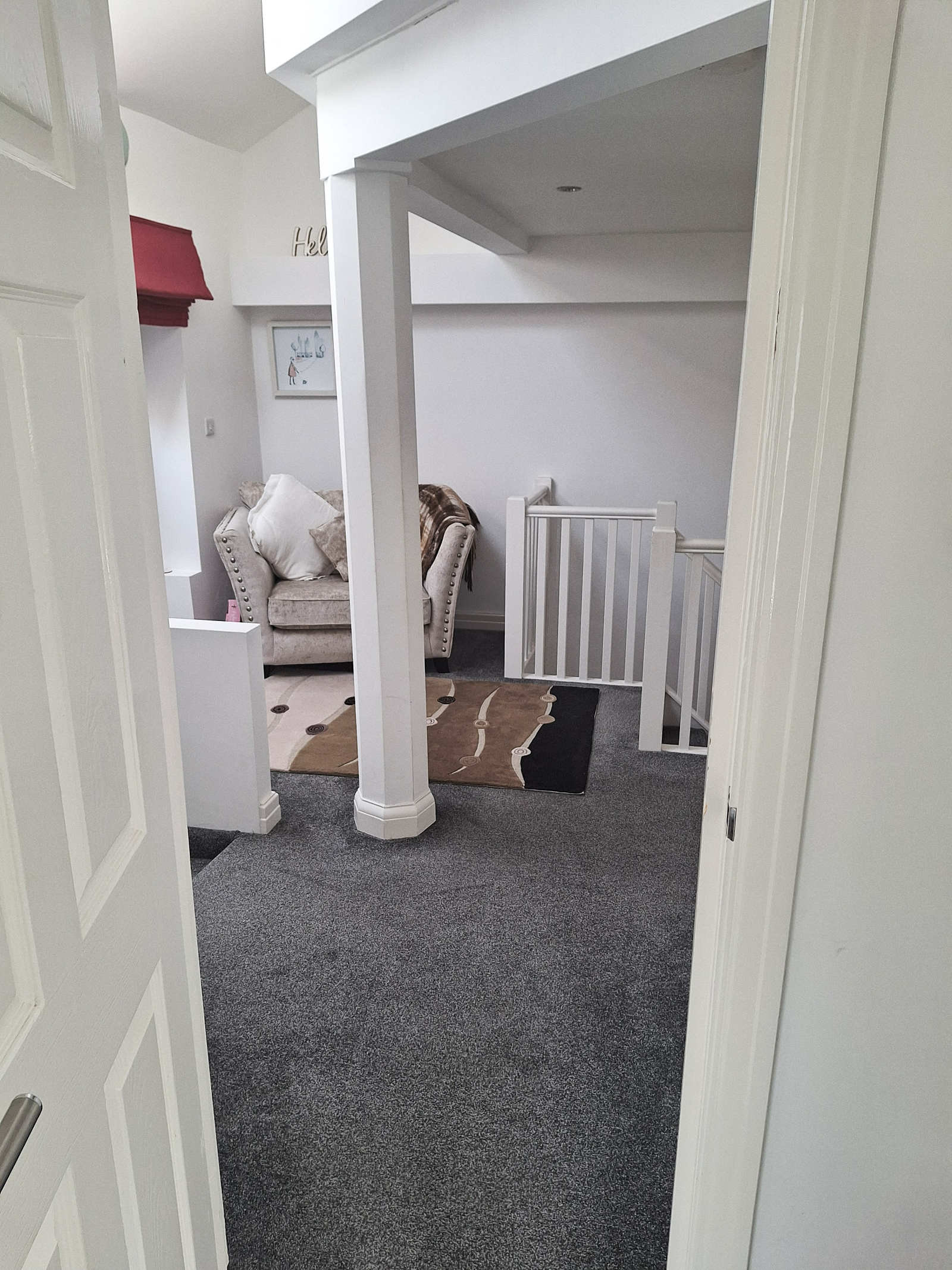 Patamar do 2º andar com sofá e mesa de escritório