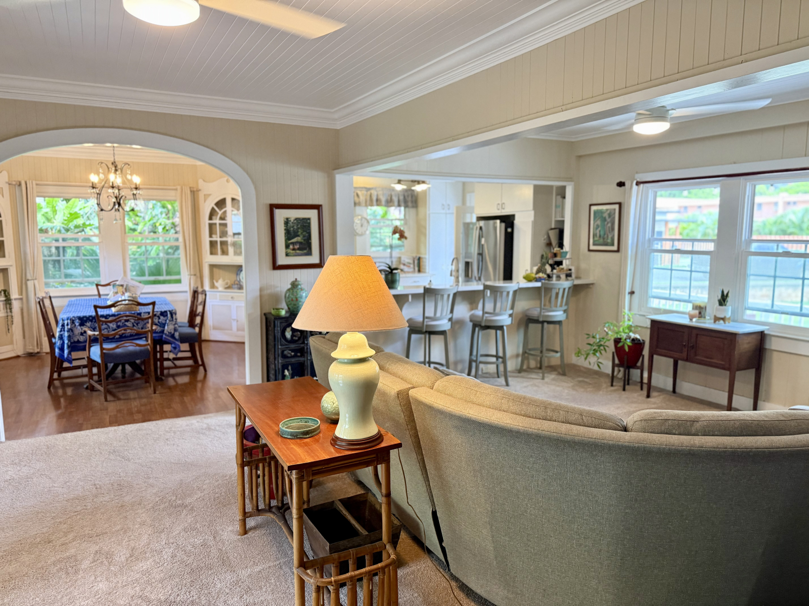 Salon avec courant ouvert menant à la cuisine et à la salle à manger