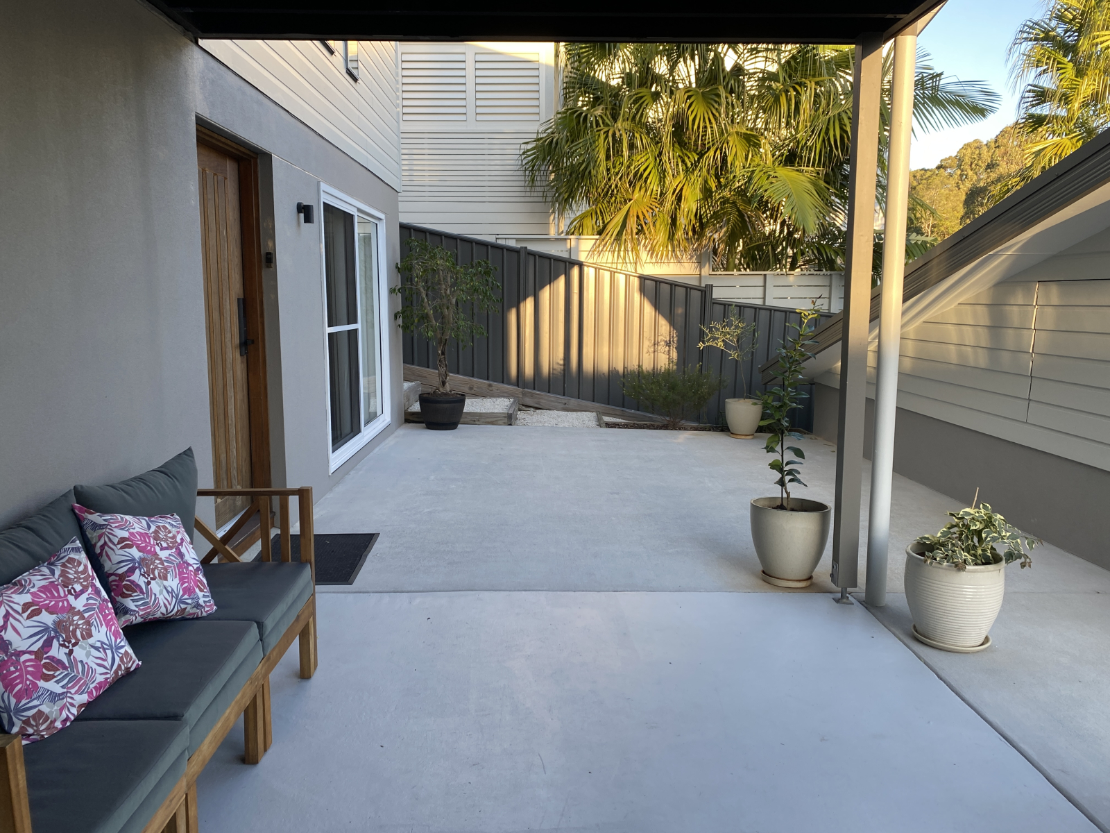 Downstairs outdoor covered space with sofa to watch the kids play out the front or just enjoy the se ...