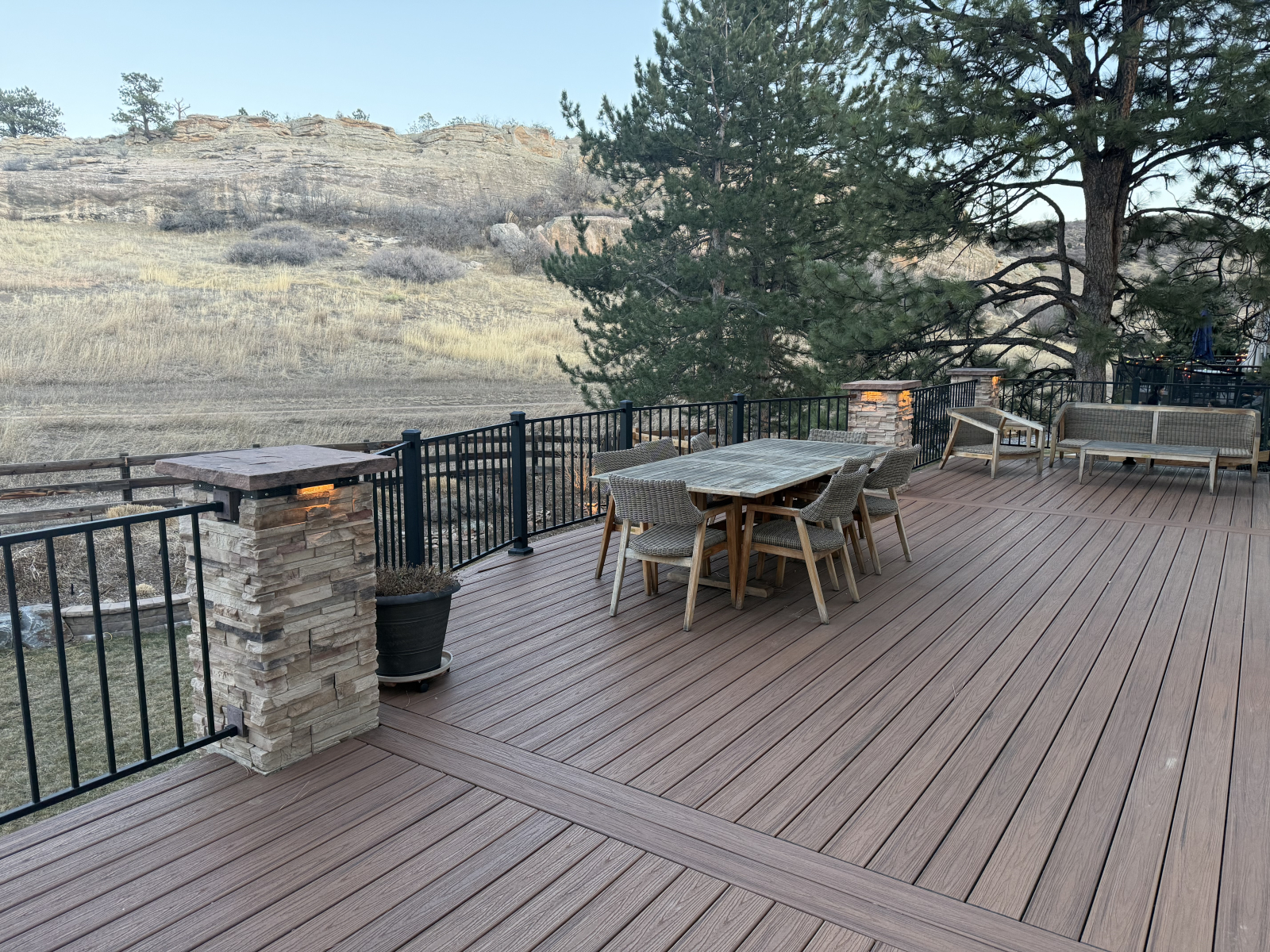 Large wrap around deck with lots of seating, dining table and grill