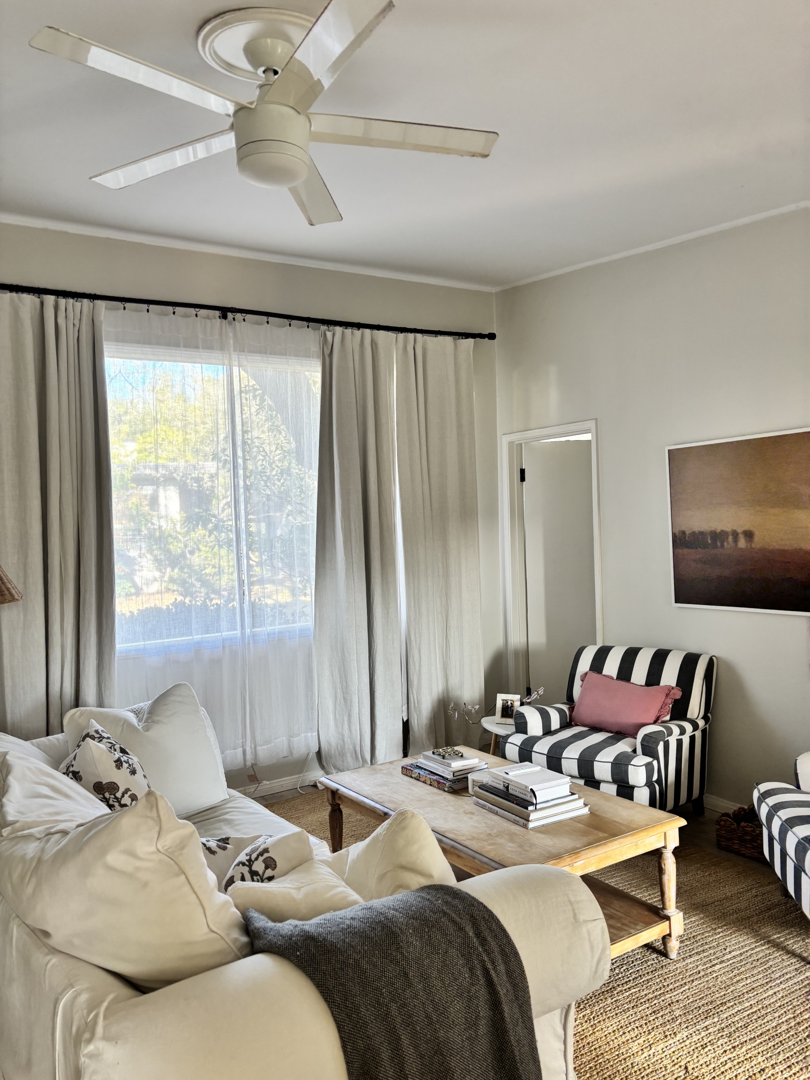 Living room with large picture window, blackout curtains, and frame TV.