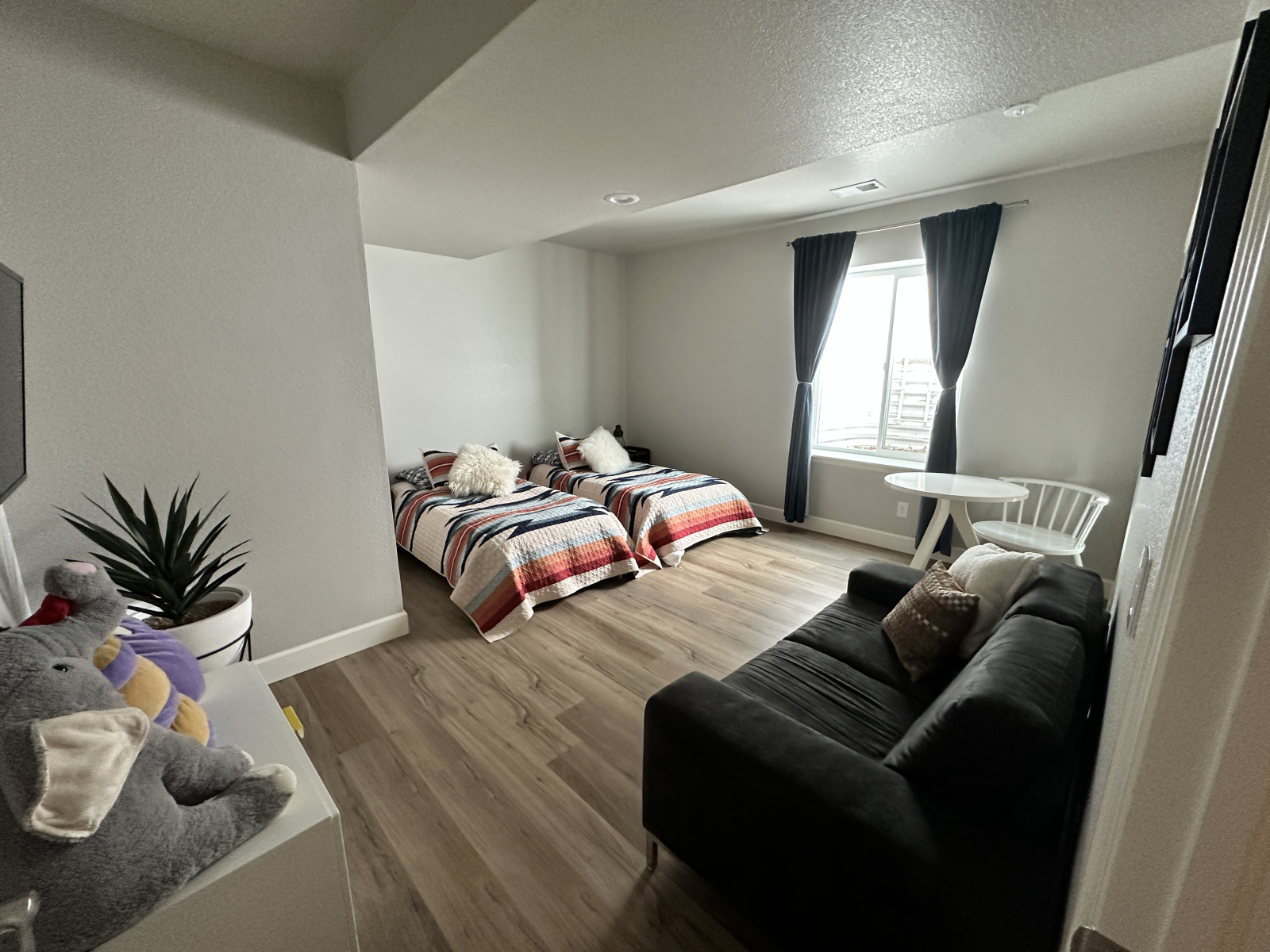 Keller-Schlafzimmer mit zwei Einzelbetten und einem bequemen Sofa.