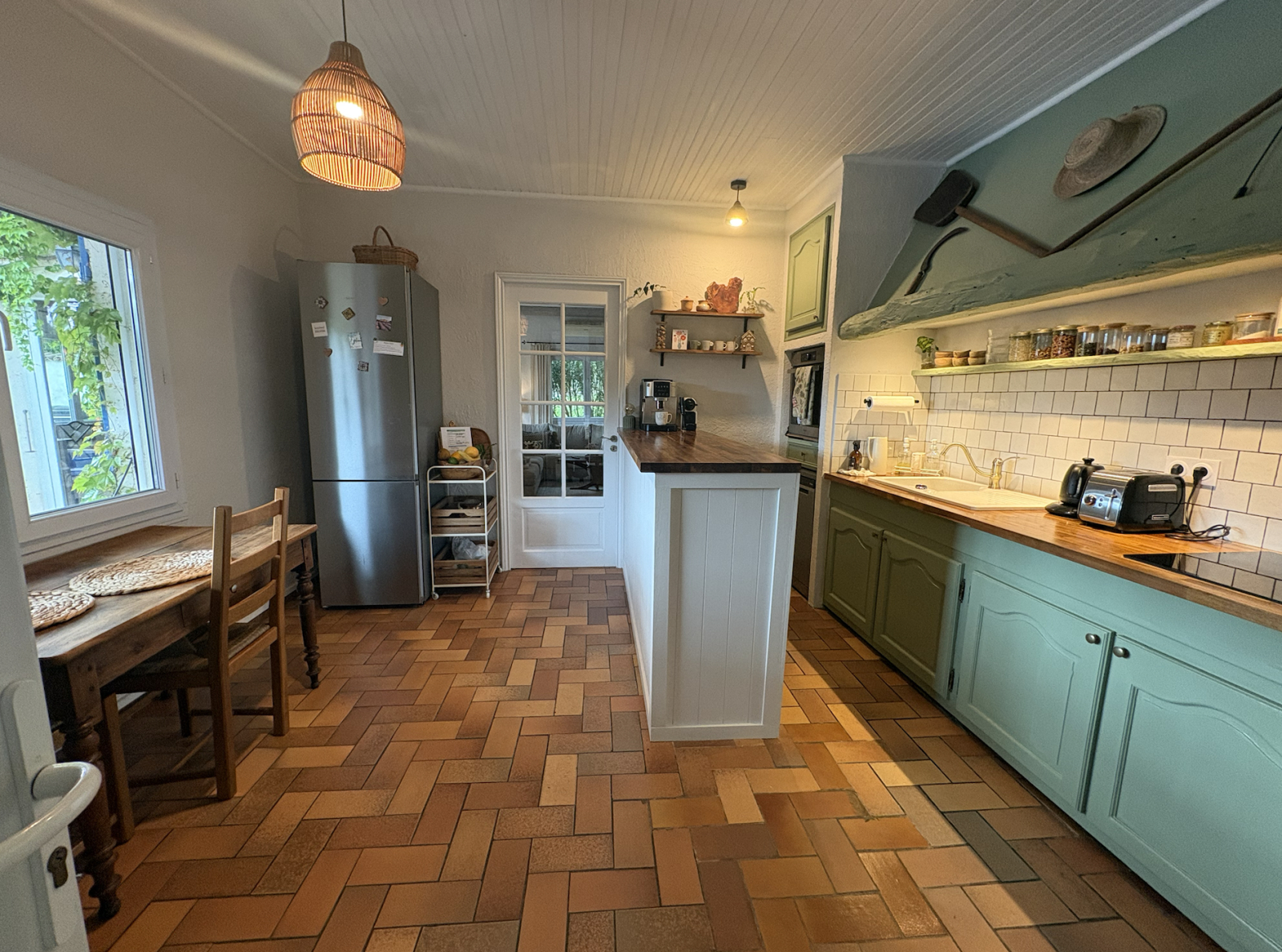Cocina totalmente equipada con mesa de desayuno con vistas a la piscina y al jardín