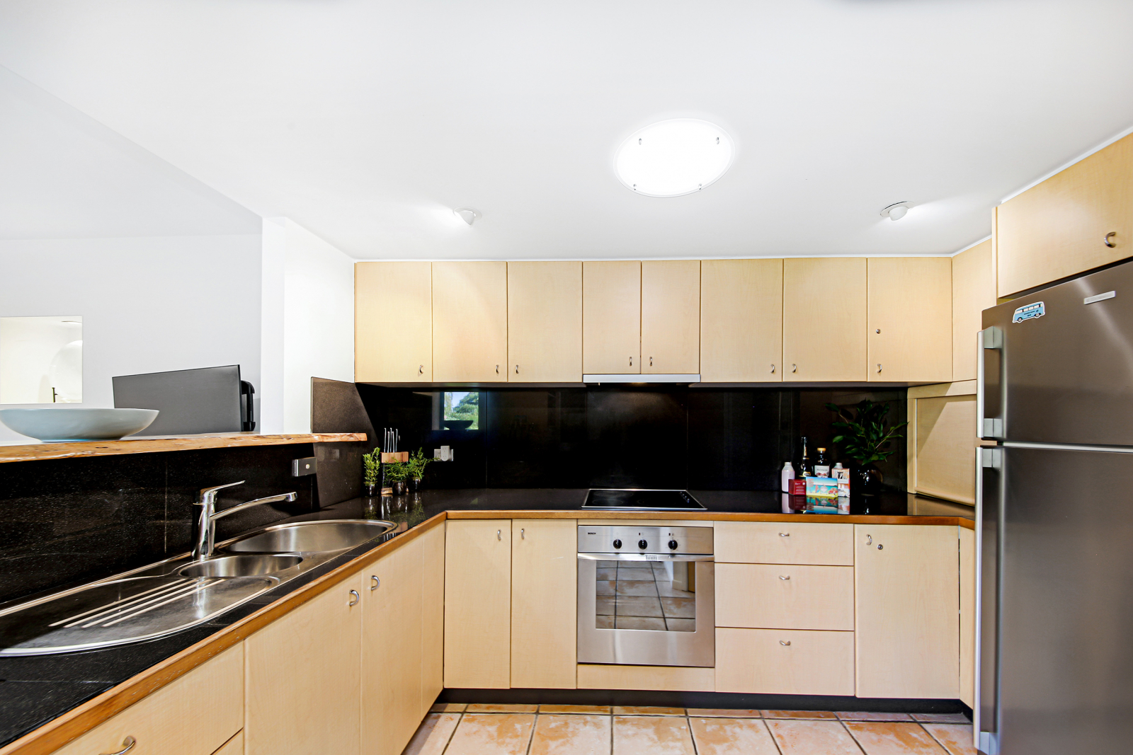 Kitchen with black granite tops, full-size fridge/freezer, and dishwasher