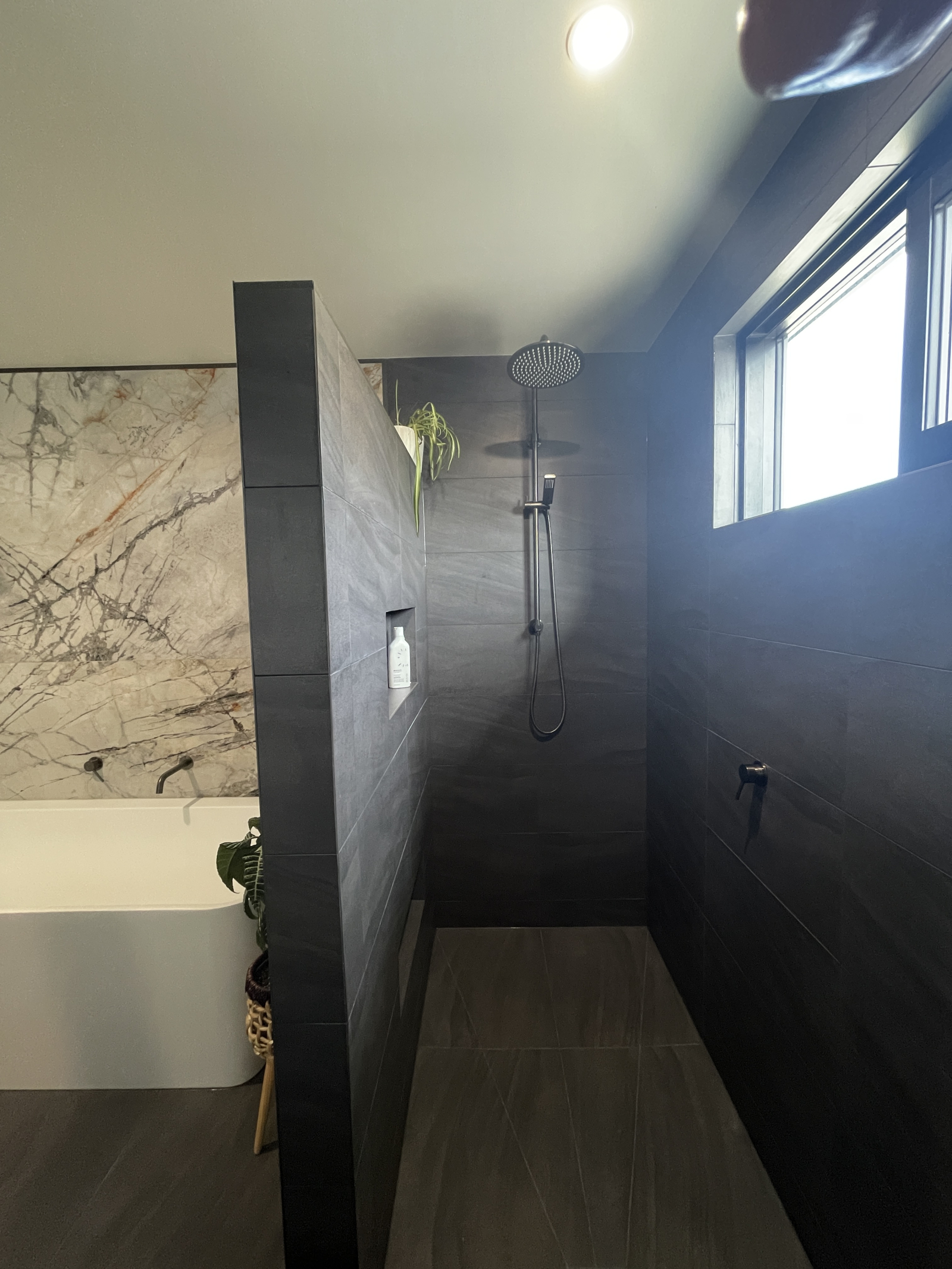 Begehbare Dusche im Hauptbadezimmer mit Hand- und Regenduschkopf. Viele Pflanzen, die ihm eine tropi ...