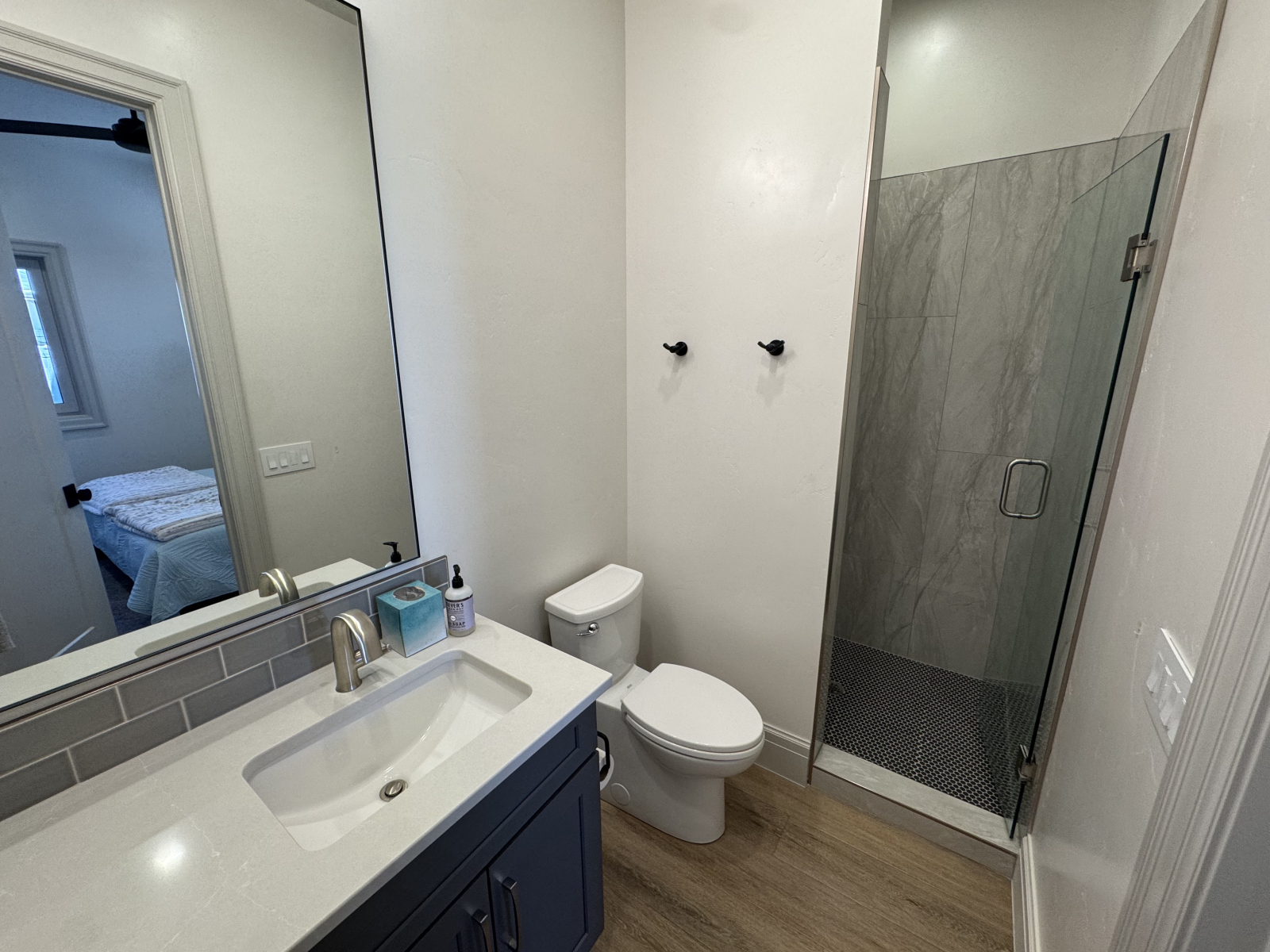 Salle de bain attenante gauche avec vue sur la douche (et reflet vers la chambre)