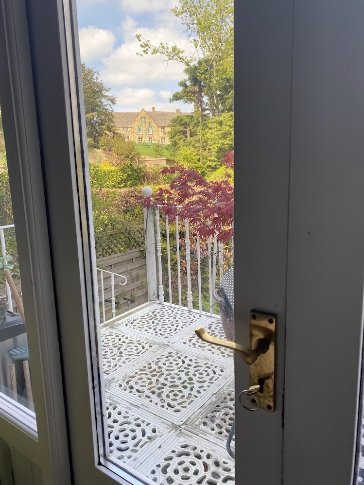 View from the kitchen door of the balcony and beyond. If you look closely you can see the playground equipment. You can access the playground from our back garden, no roads to cross and older children 7+ often play here without their adults. (you can still hear them if the door is open)