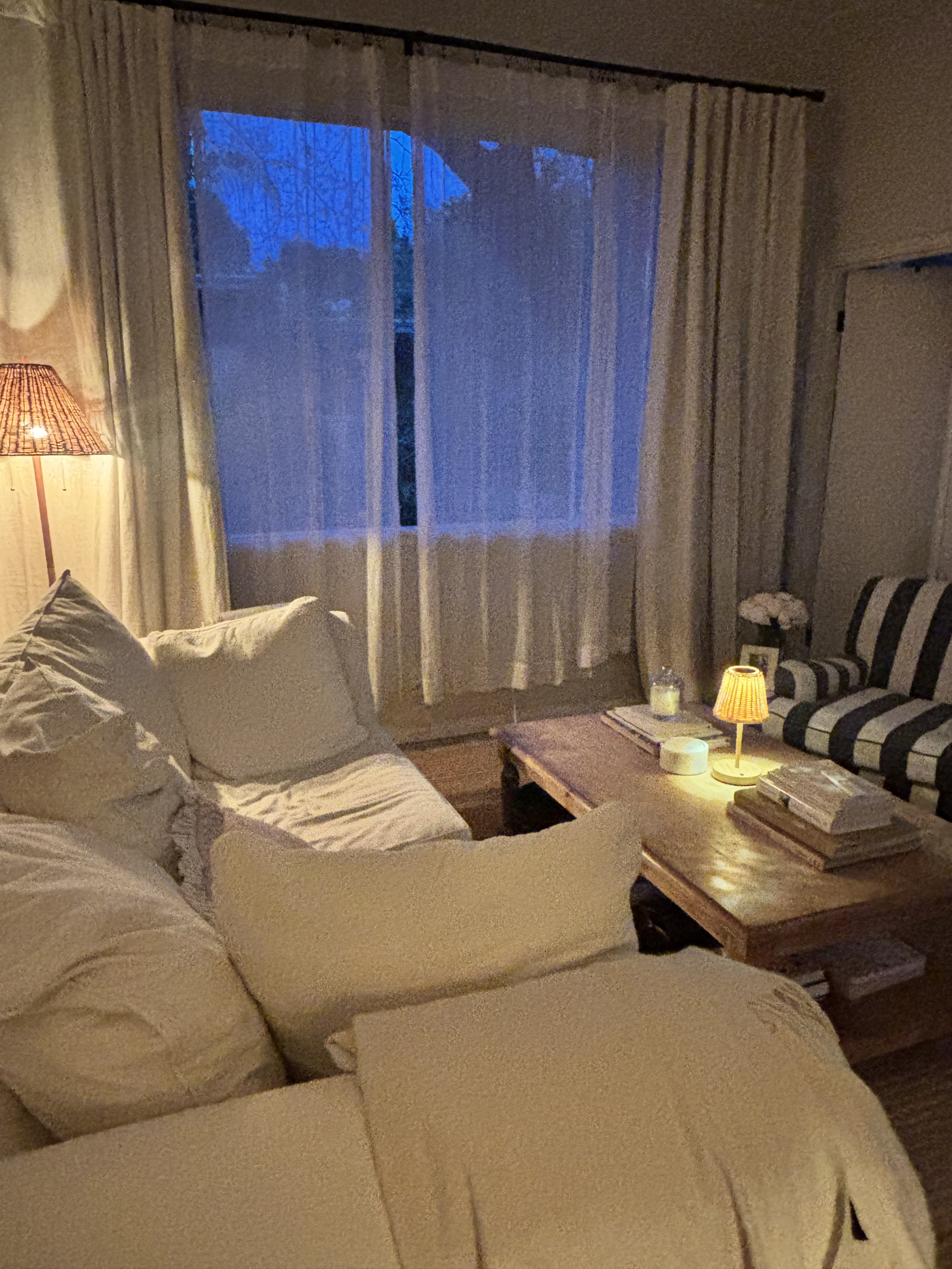 Salón por la noche con gran ventana panorámica y sofá cómodo