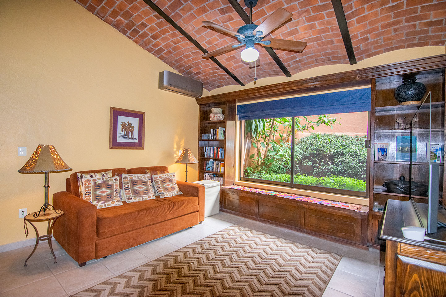 Sofá-cama confortável na sala de TV com dispositivo de streaming de internet.