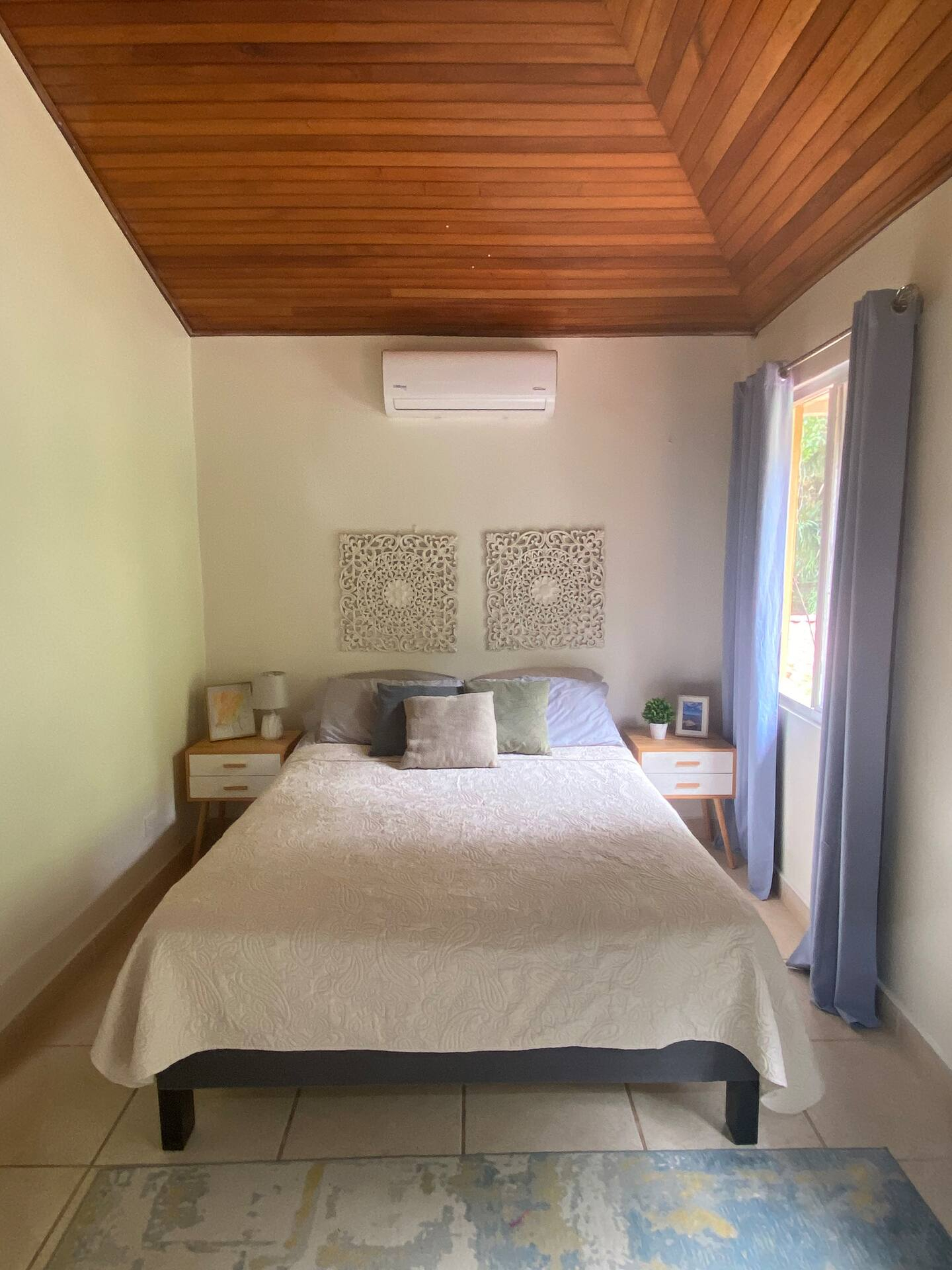 Camera da letto al piano superiore confortevole con letto matrimoniale, unità di condizionamento, ventilatore a soffitto e spazio per l'armadio disponibile.