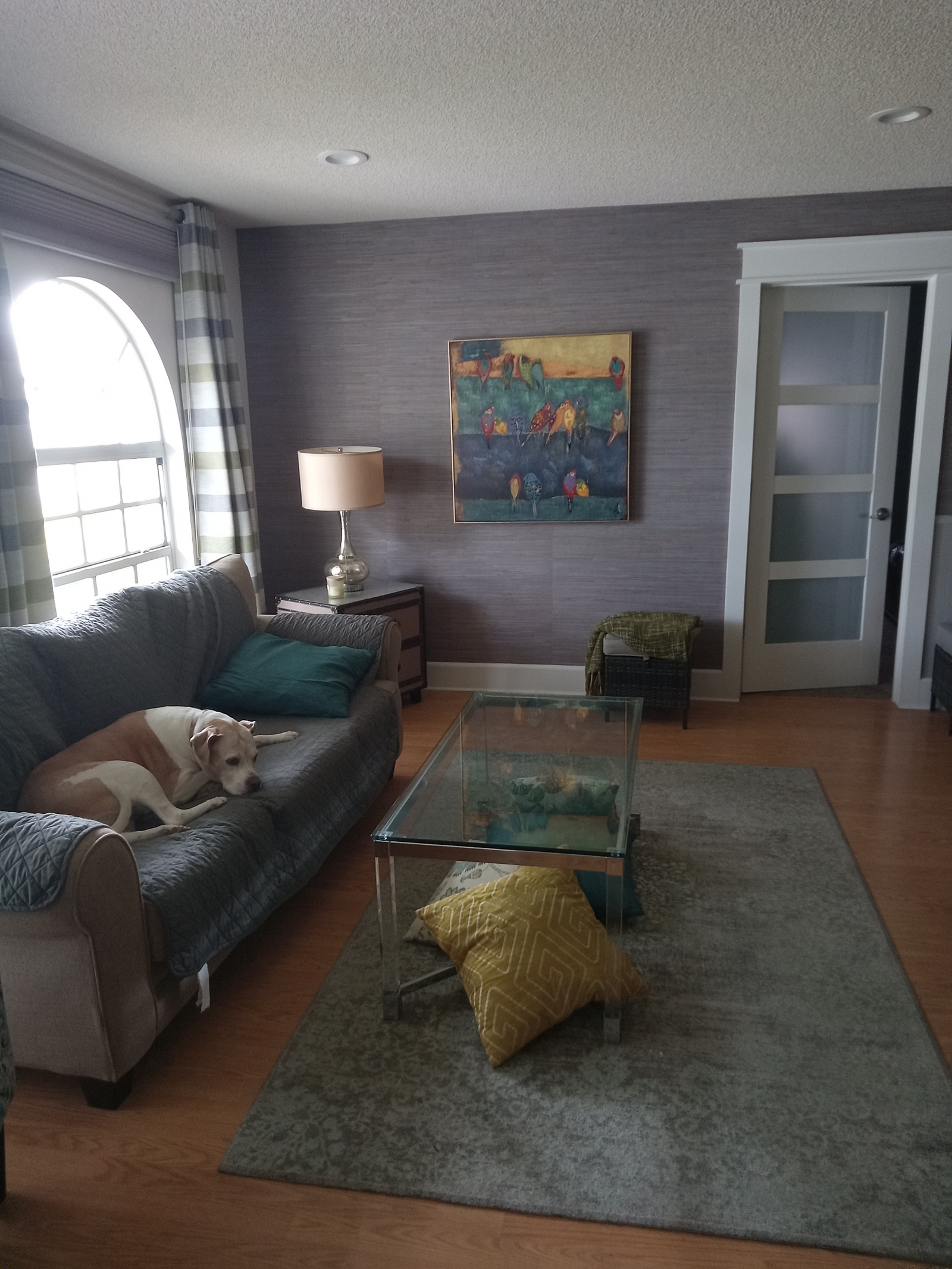 De woonkamer met uitzicht op de voortuin. De open deur leidt naar de hoofdslaapkamer.