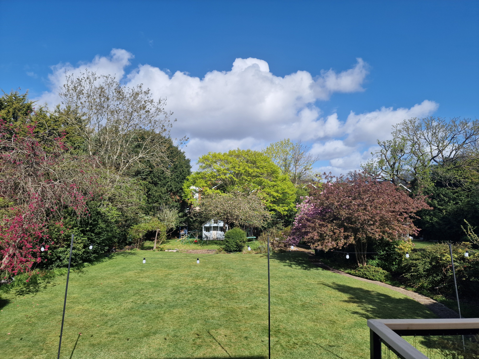 Back garden with plenty of garden toys to keep kids entertained including a playhouse